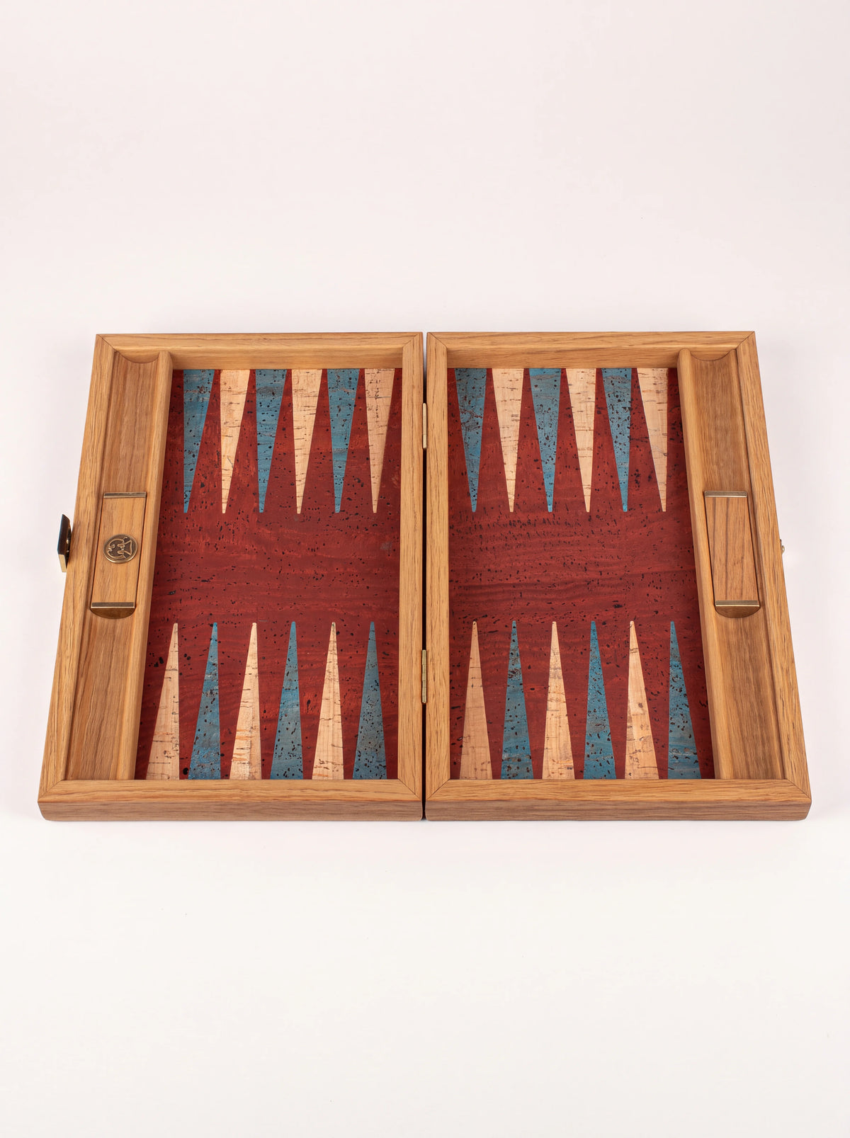 Empty open backgammon board showing the red cork surface and integrated wooden checker racks