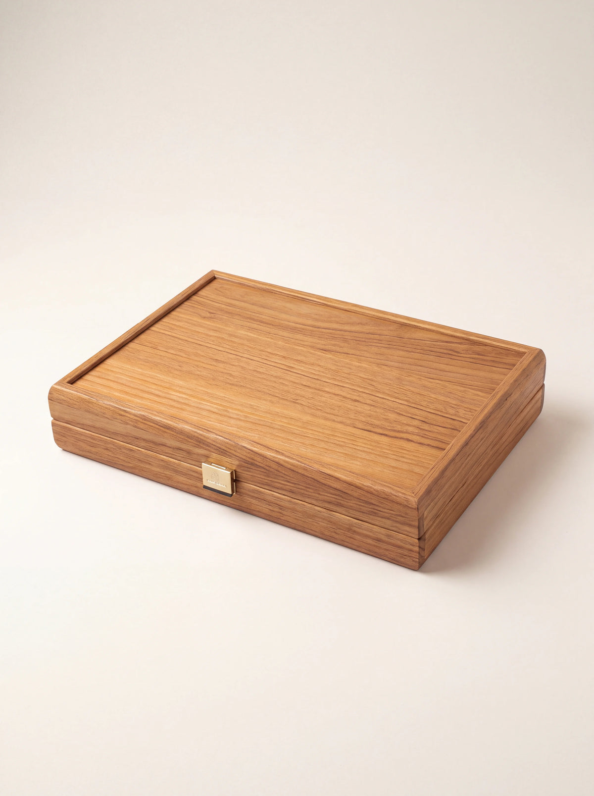 Closed oak wood backgammon case with a brass clasp on the front edge