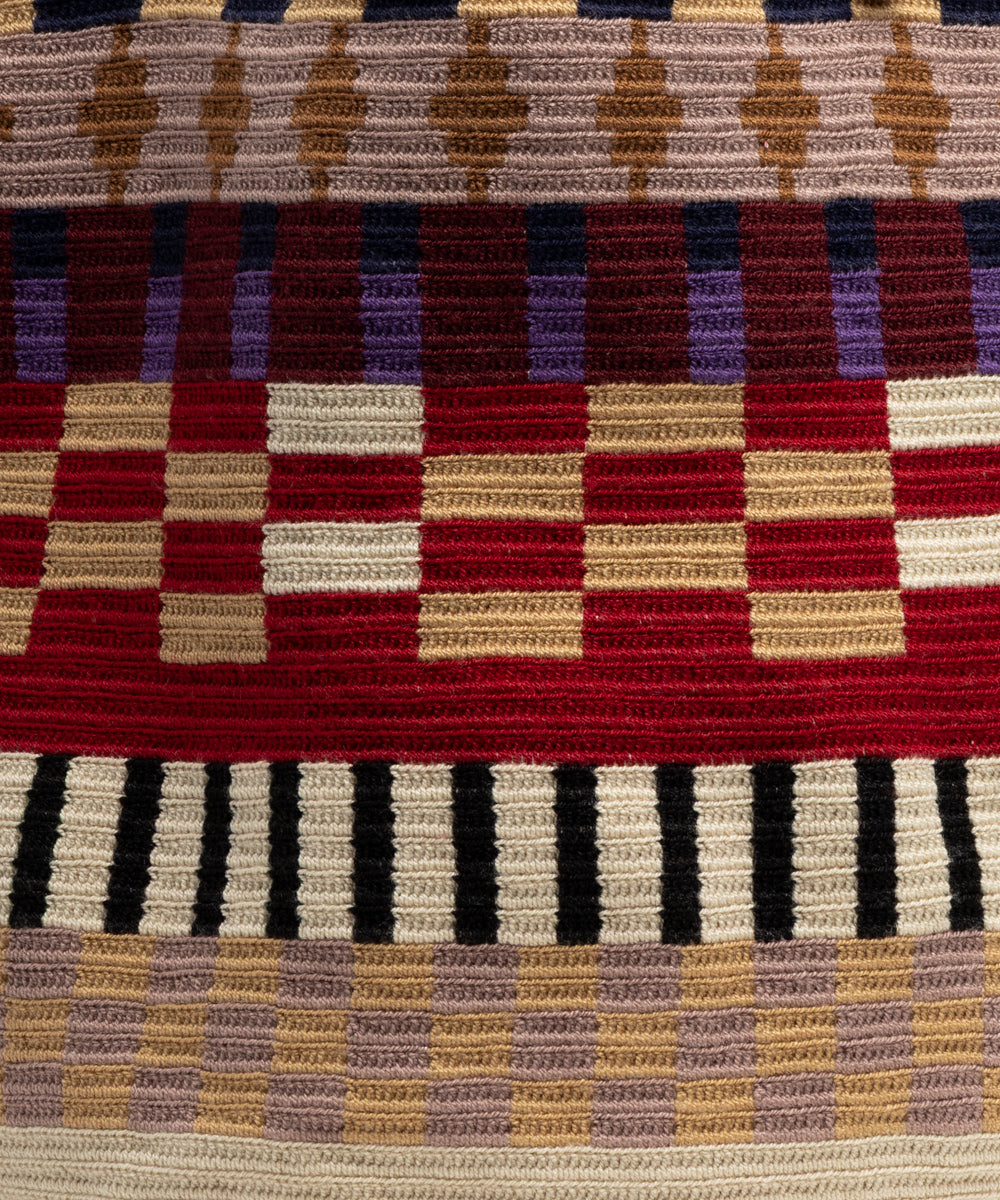 Detail of the multicoloured crochet pattern showing tight horizontal ribbing and checkerboard bands