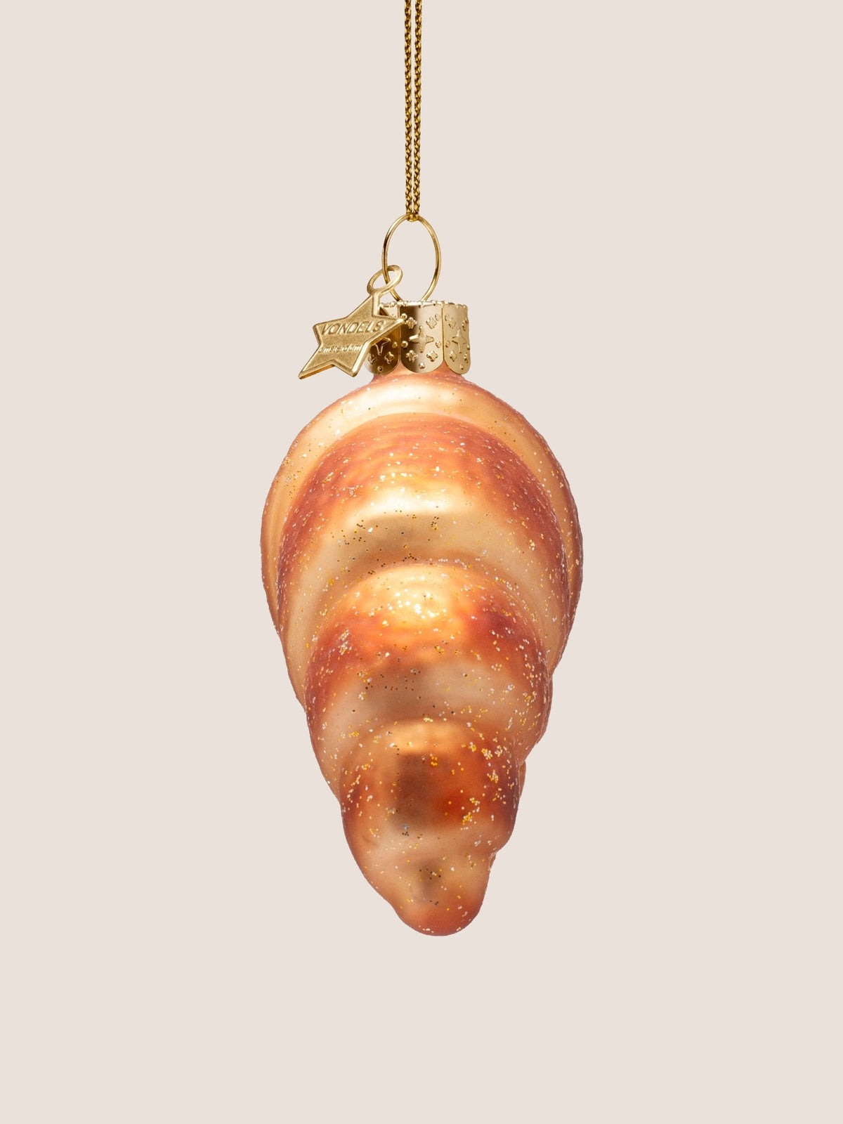 Side profile of the croissant ornament showing its rounded thickness and tapered tip