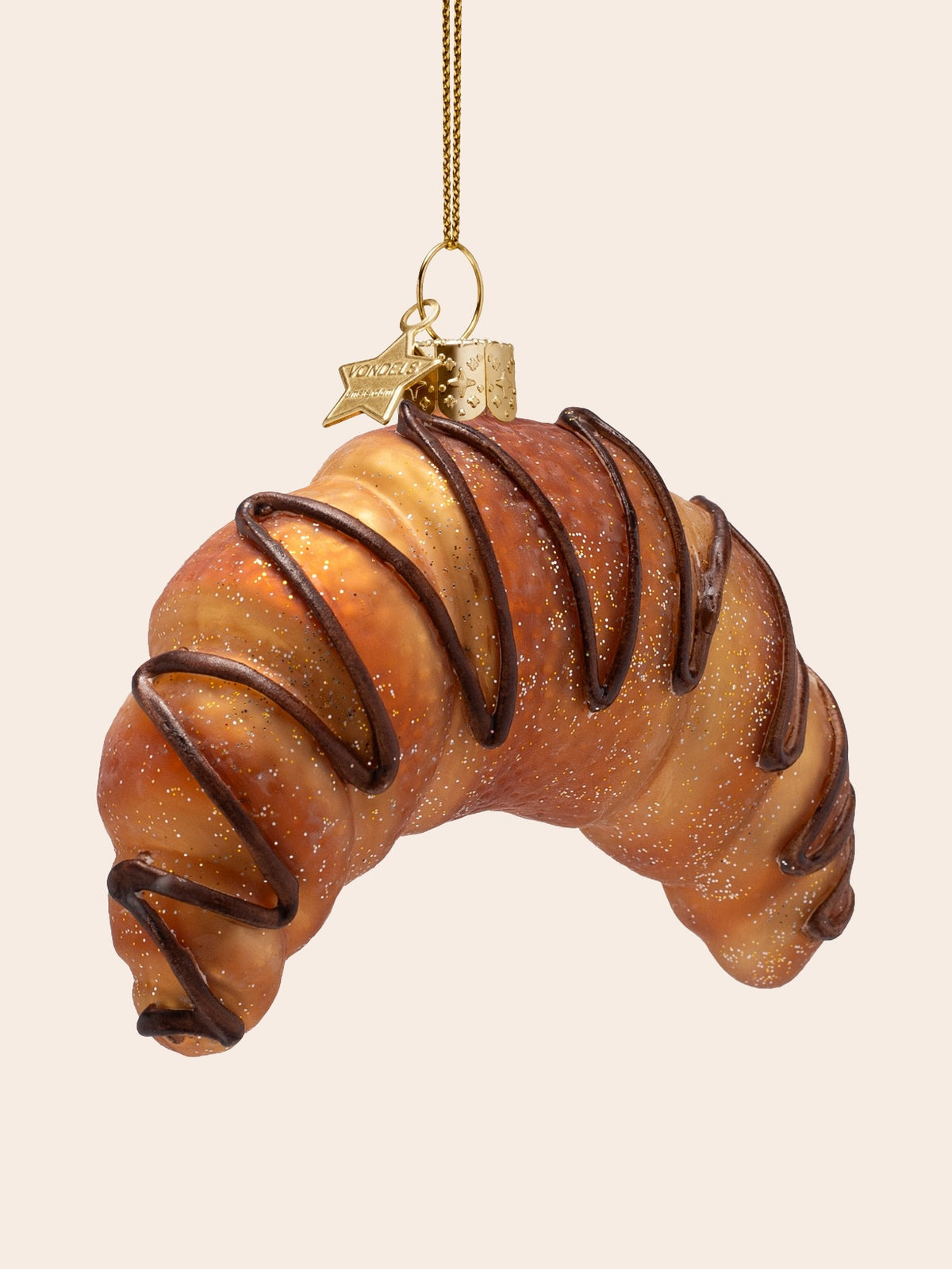 Three-quarter view of the croissant ornament showing its crescent curve and layered pastry texture