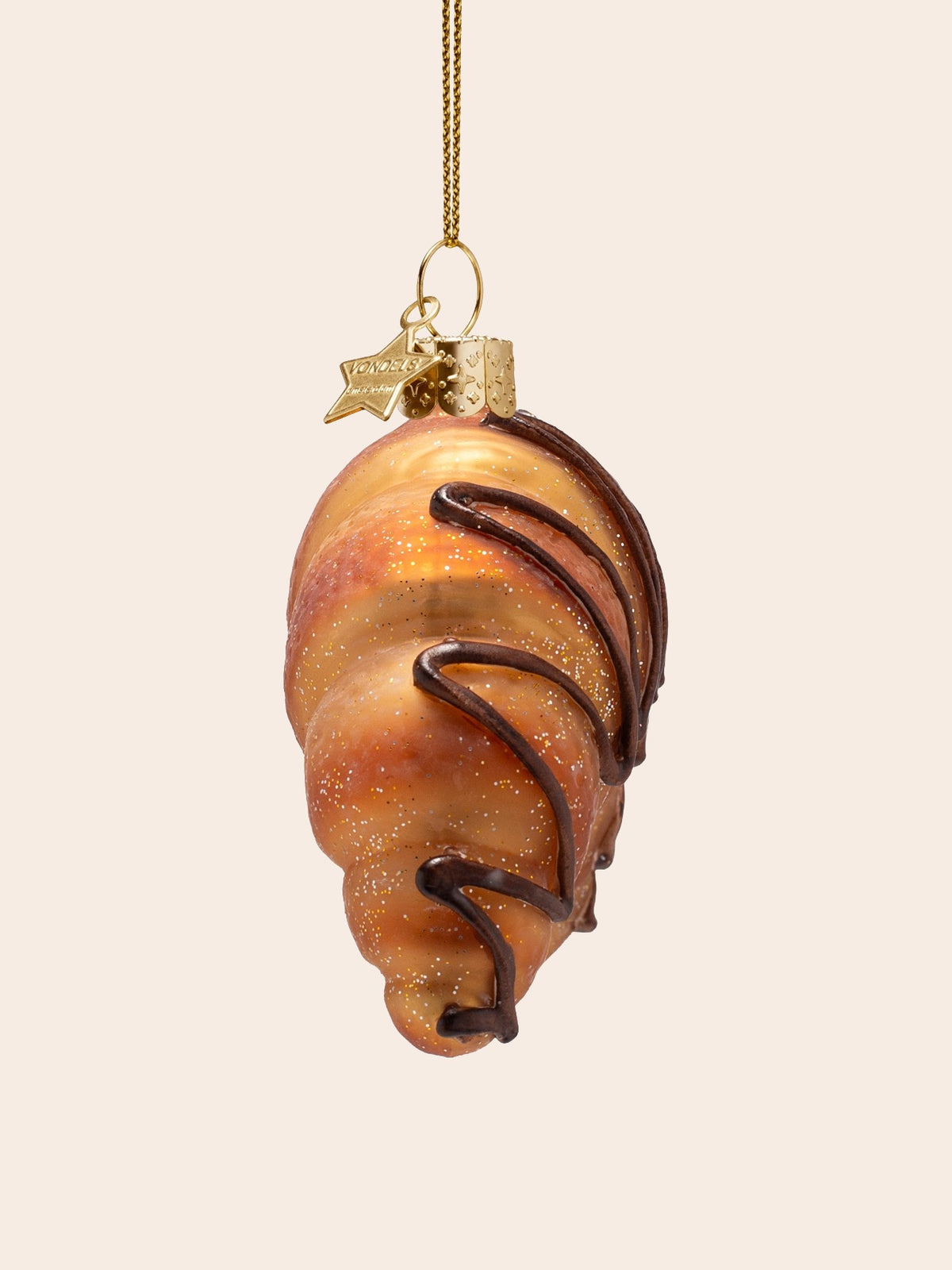 Side profile of the glass croissant ornament showing the rolled shape and chocolate piping