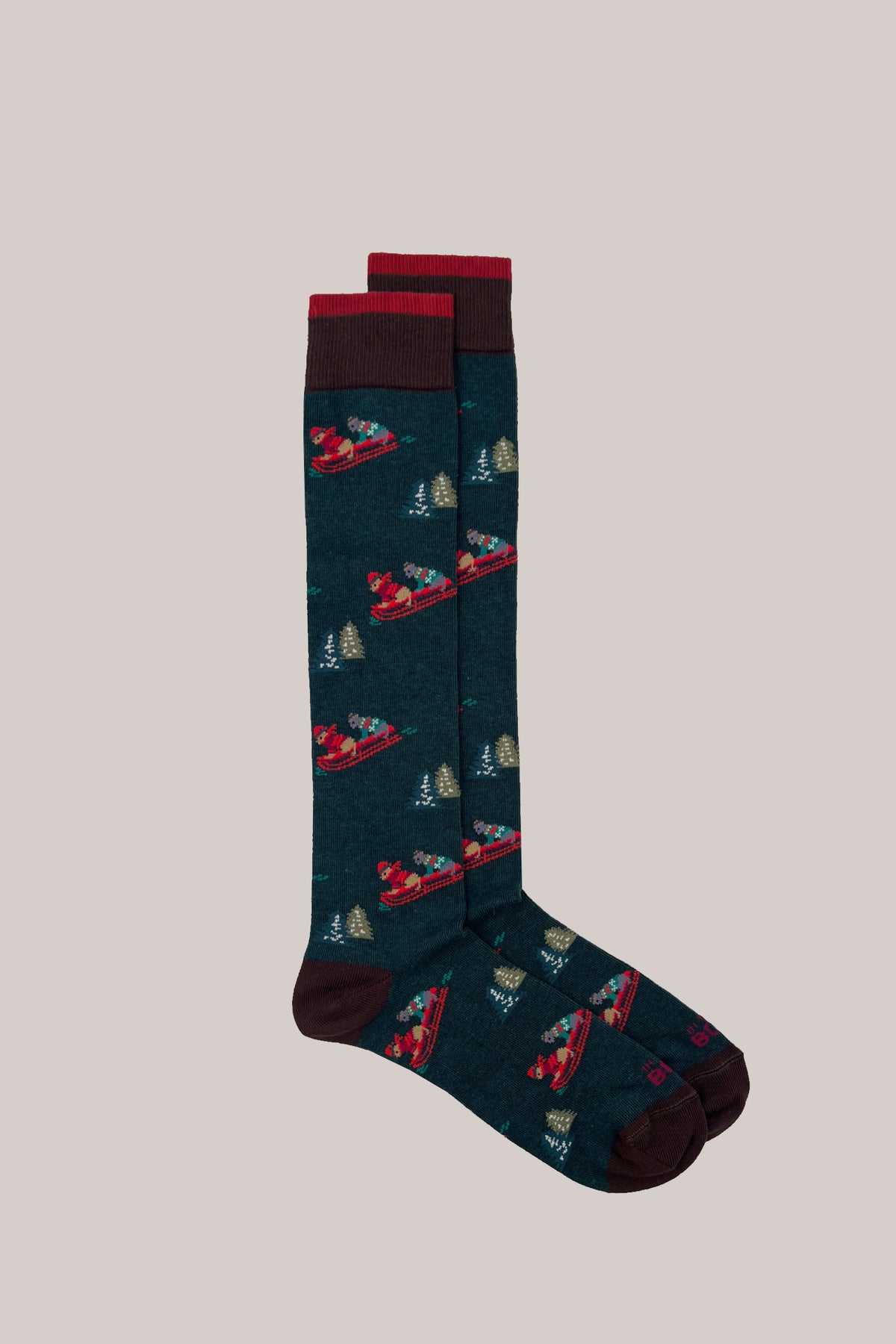 Dark green knitted socks patterned with dogs on sledges and pine trees, with contrasting cuffs, heels and toes