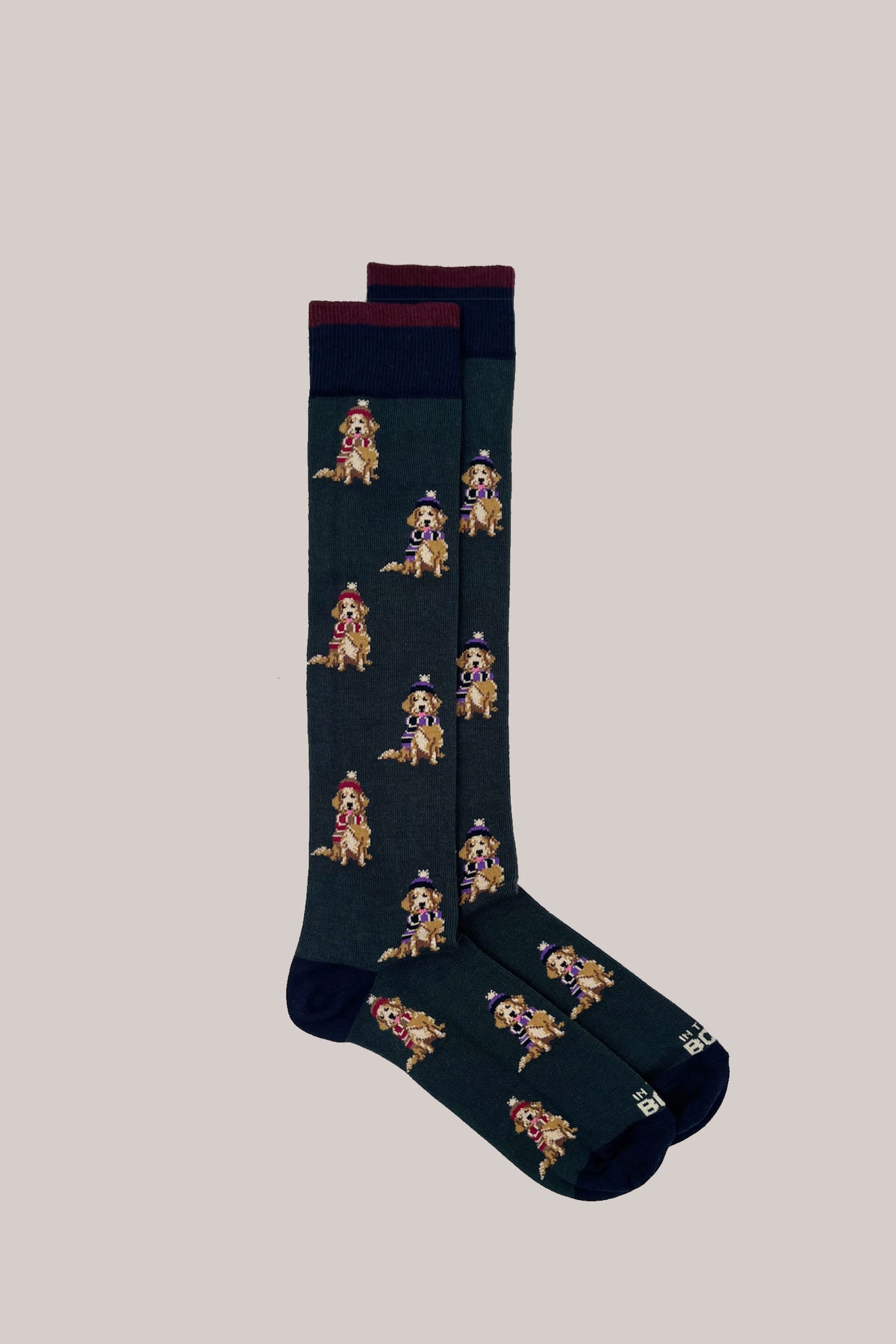 Dark green calf-length cotton socks with an all-over motif of dogs in winter hats, with navy cuffs and toes