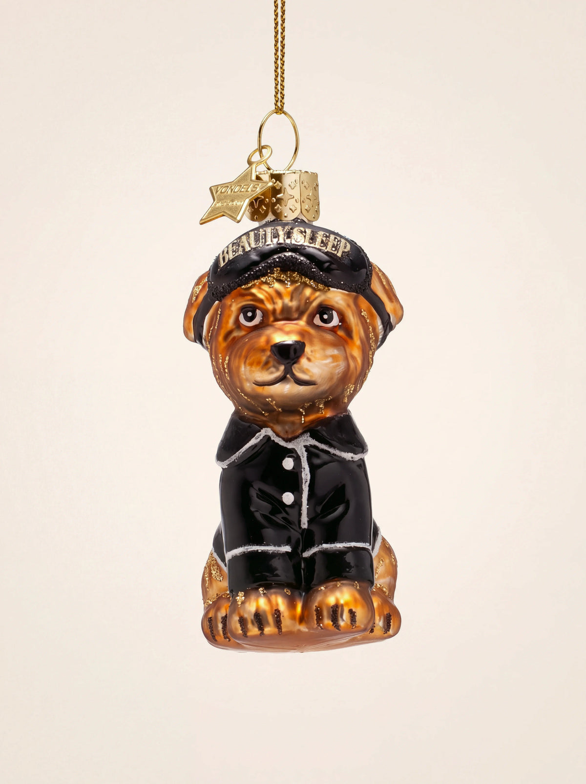 Mouth-blown glass dog ornament in black pyjamas with a sleeping mask inscribed BEAUTY SLEEP