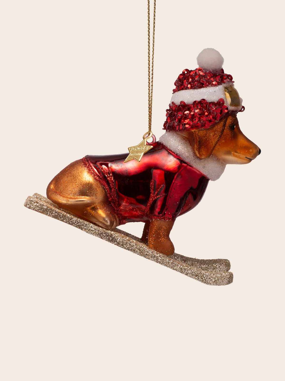Dog on skis glass ornament from the right side, showing the seated pose on the glittered skis