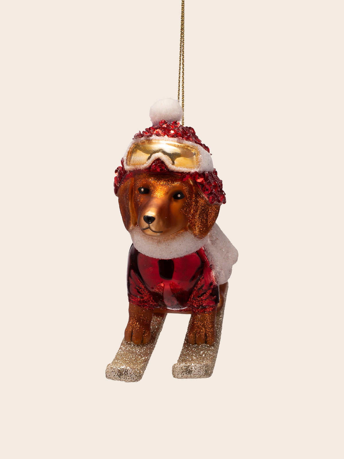 Front view of the dog on skis ornament, showing gold ski goggles on the hat and painted facial features