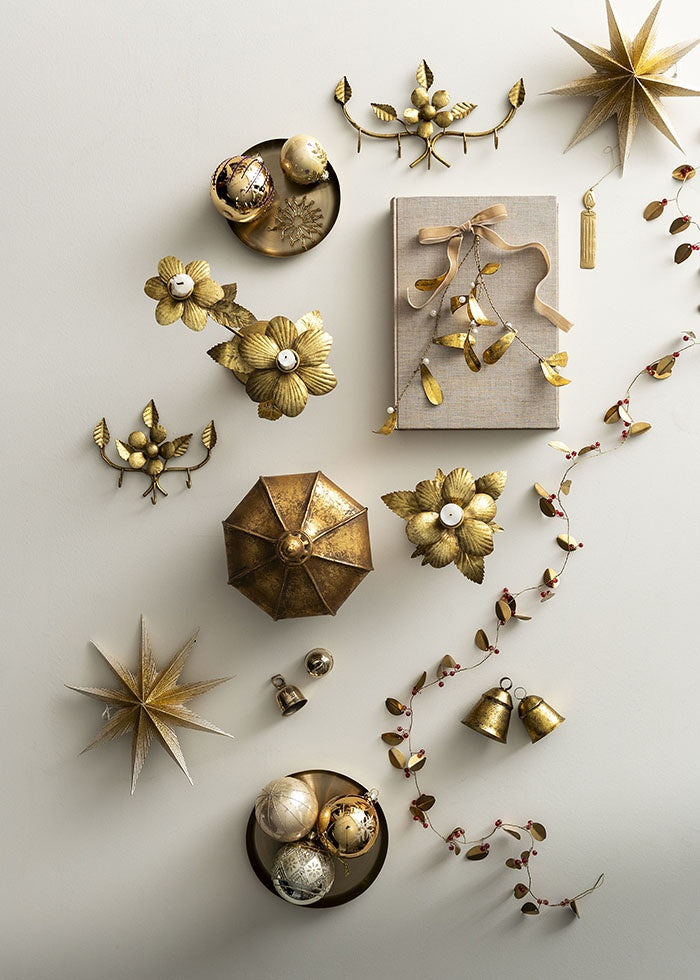 Golden iron bells arranged amongst festive Christmas ornaments, stars and candle holders