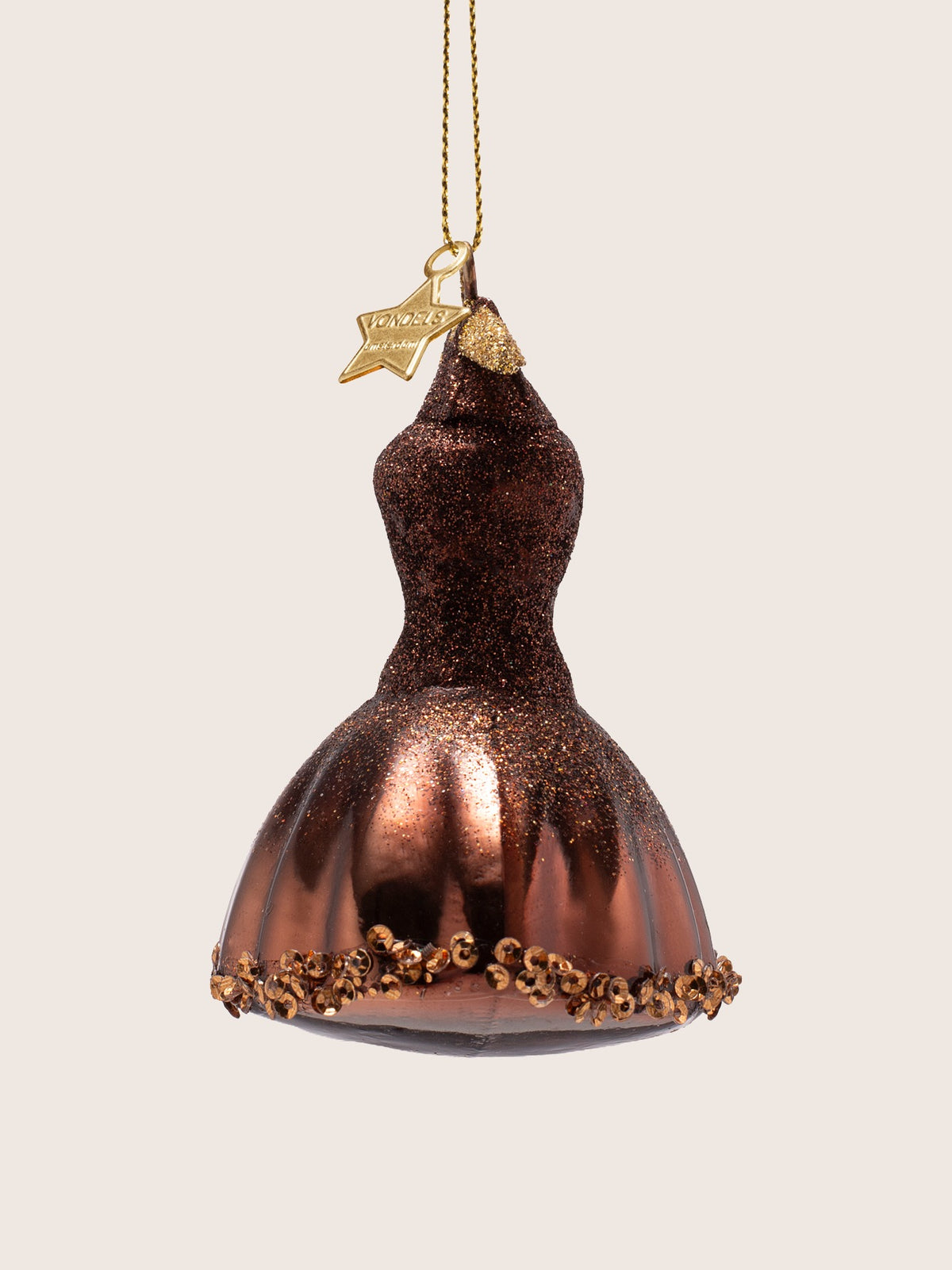 Profile view of the brown glass dress ornament with gold loop hanger and star tag