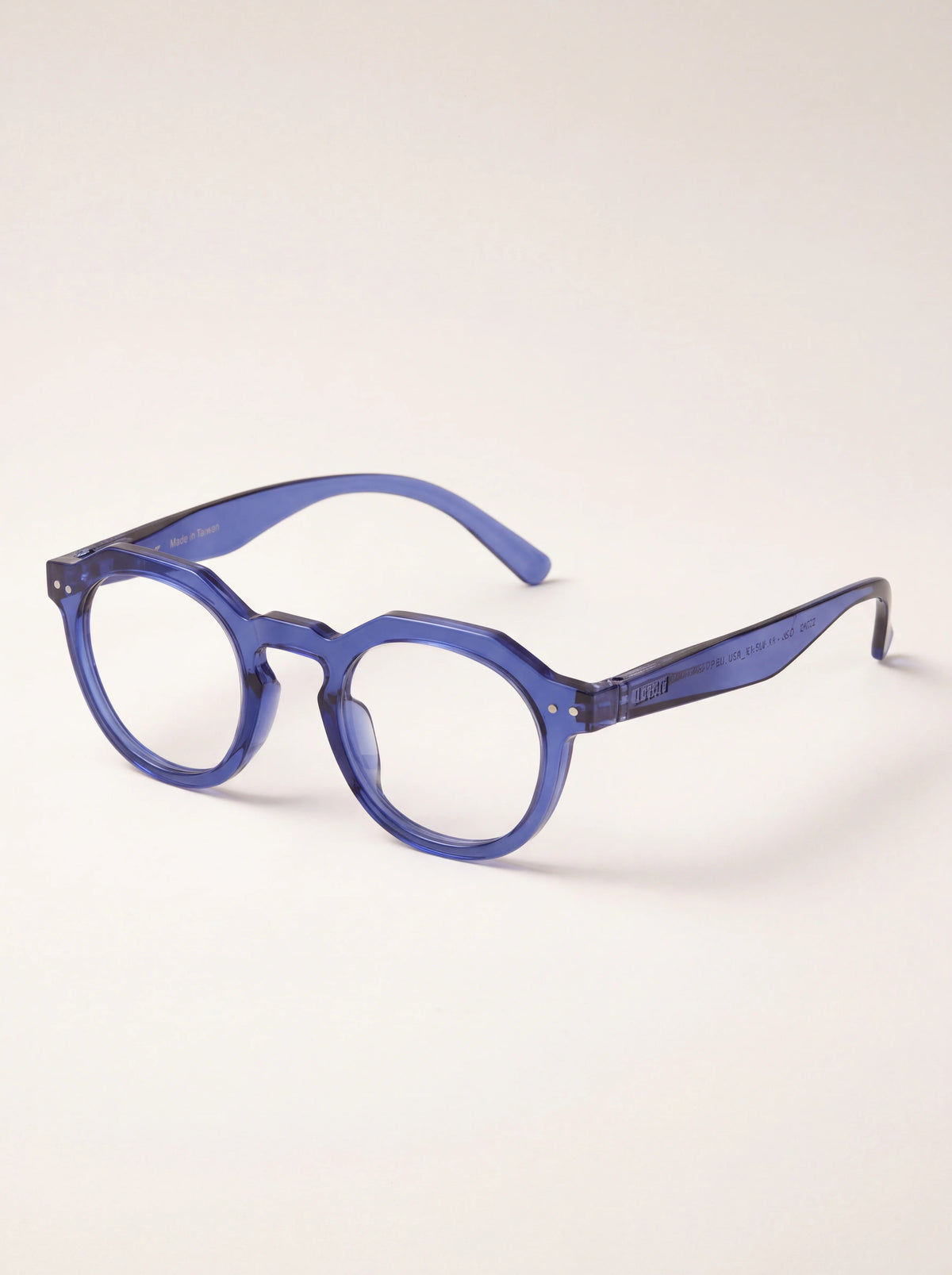 Reading glasses seen at an angle, showing the translucent blue arms and hinge rivets