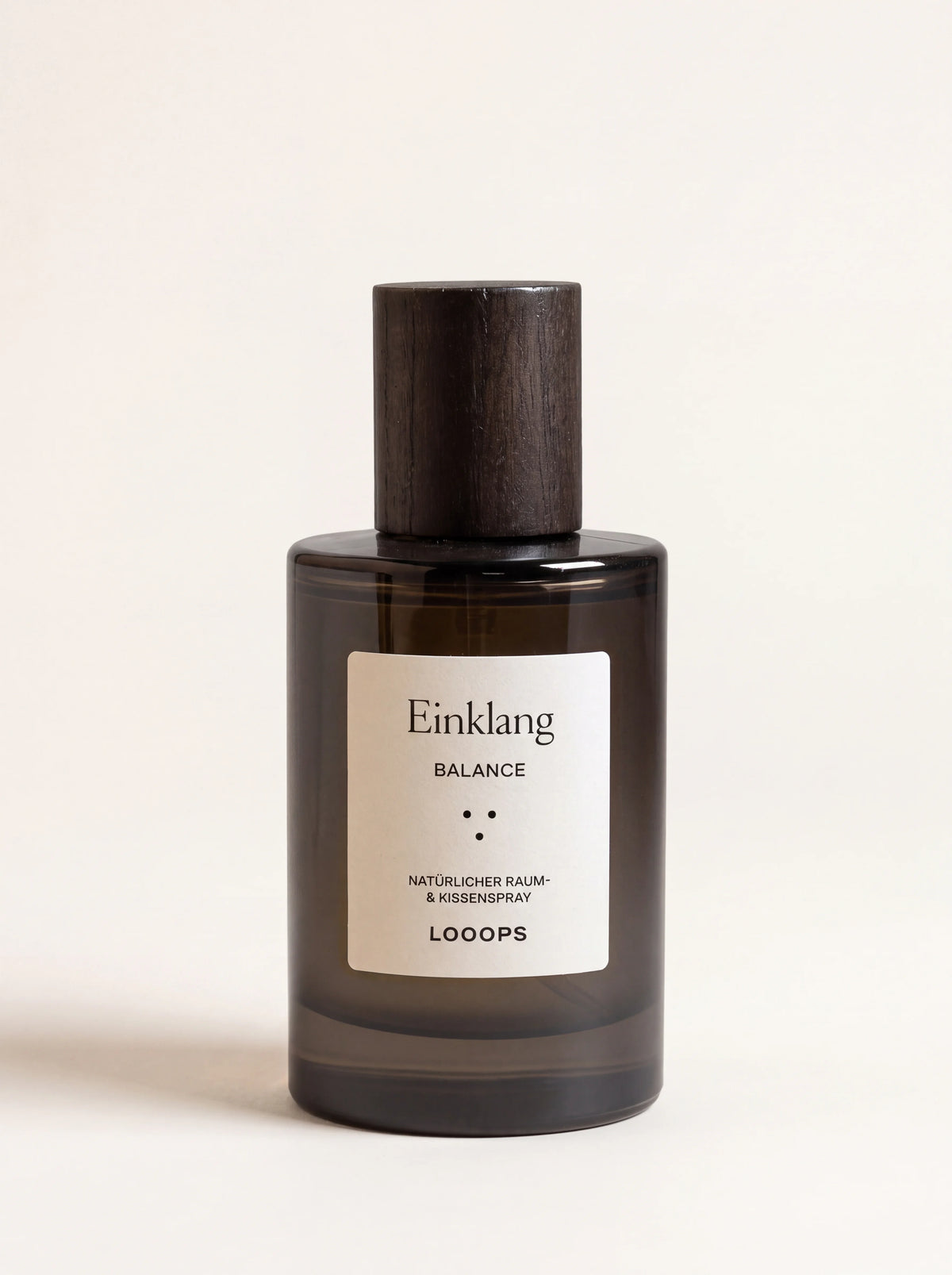 Dark glass room spray bottle with a stained ash wood cap and white label reading Einklang Balance