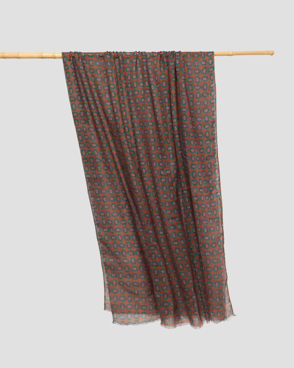 Brown wool scarf draped over a rail, showing its lightweight weave, full length, and softly frayed hem