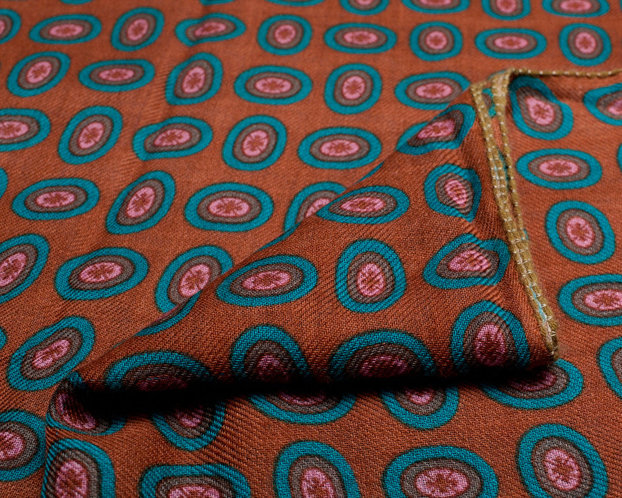 Close-up of the printed brown wool scarf, showing the fine woven texture and sewn edge detail