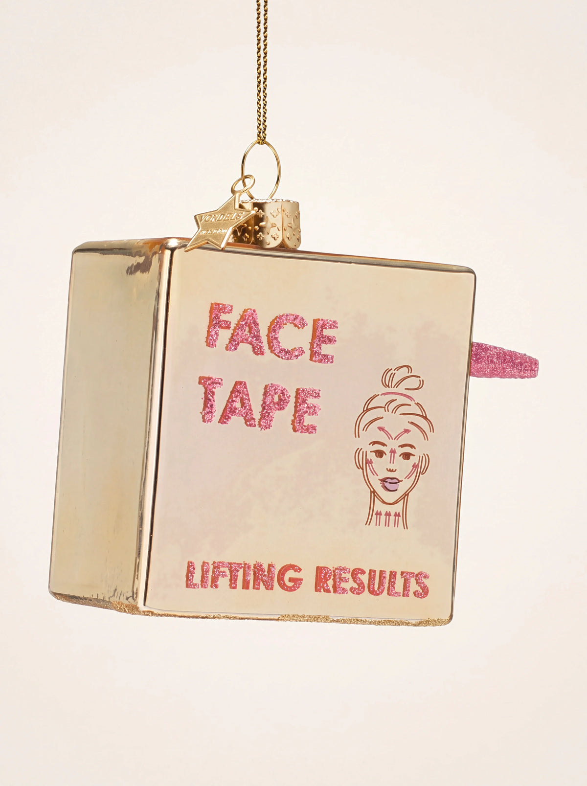 Metallic gold glass box ornament with pink glitter lettering reading Face Tape and Lifting Results