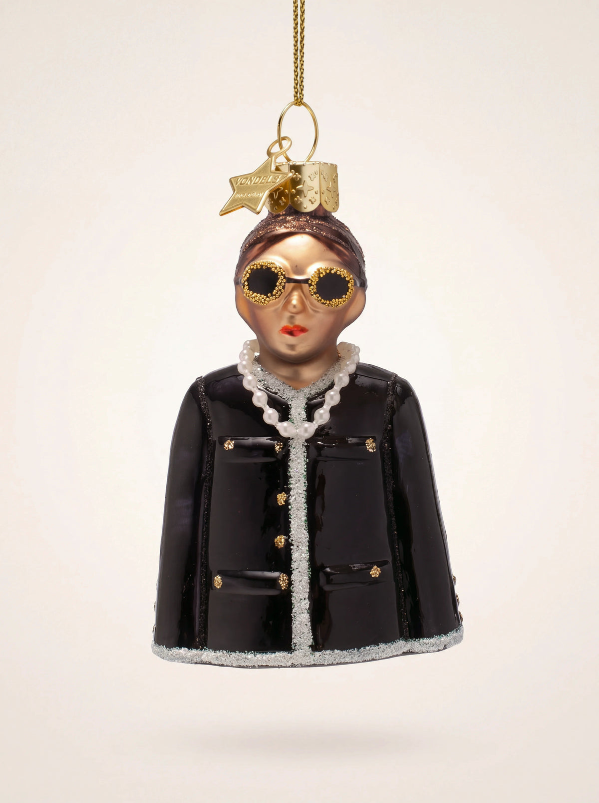 Glass woman ornament wearing round glitter sunglasses, a pearl necklace and a black jacket with silver trim