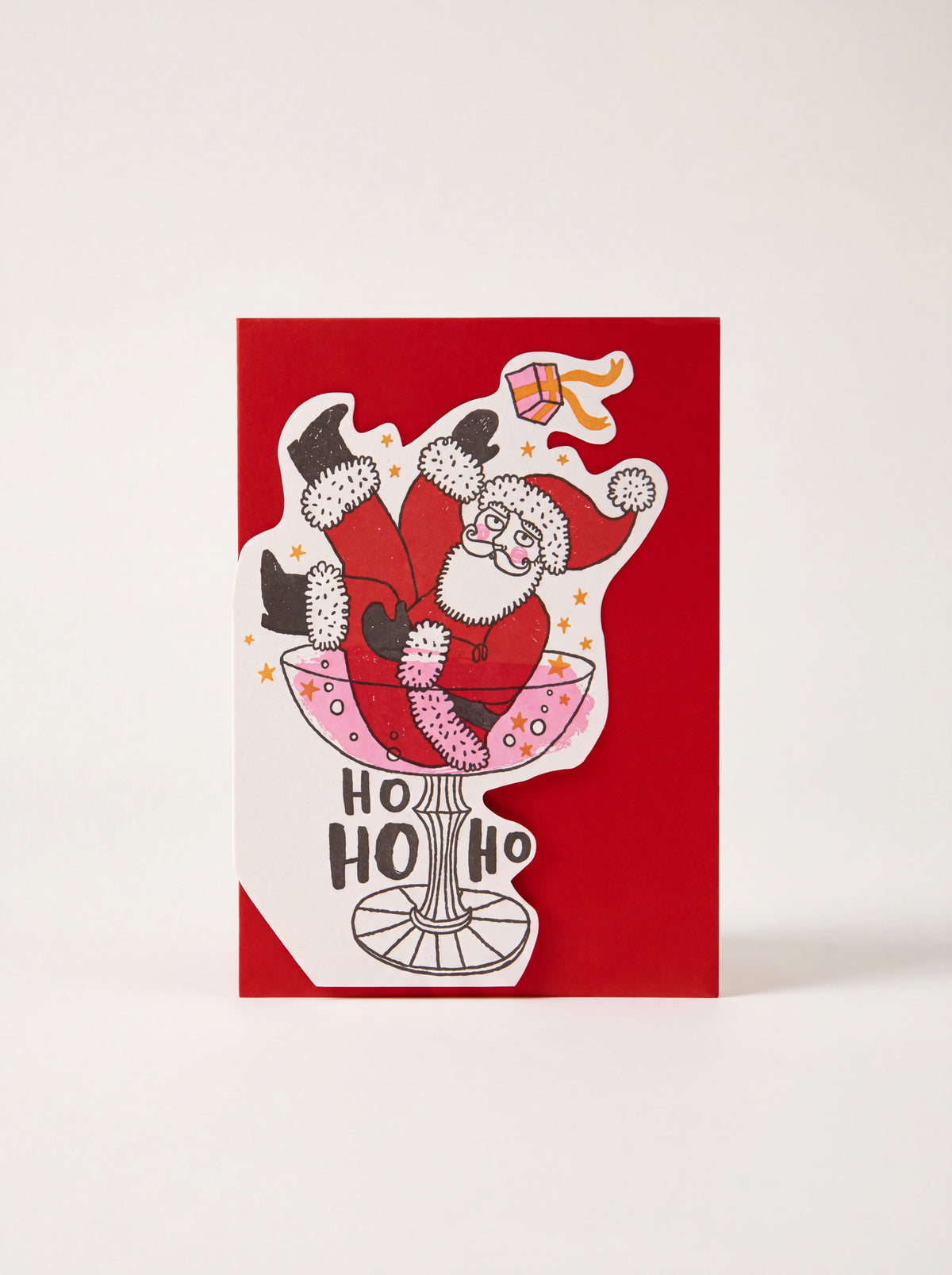 Red paper cut-out card featuring Father Christmas in a cocktail glass with HO HO HO text