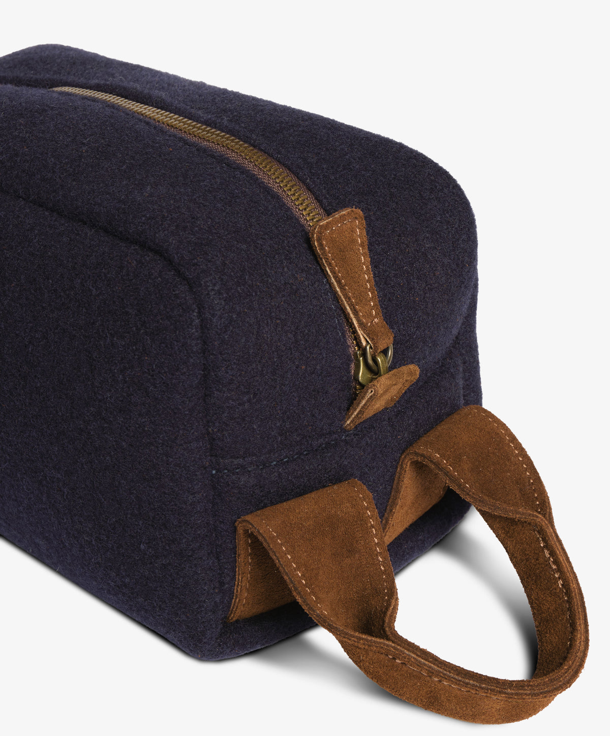 Close-up of the metal zip, brown suede pull tab and stitched suede handle