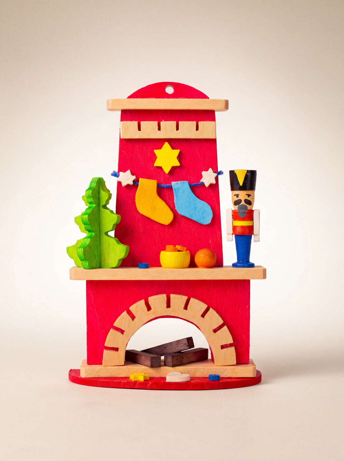 Painted sycamore wood fireplace ornament with miniature nutcracker, tree, hanging stockings and hearth