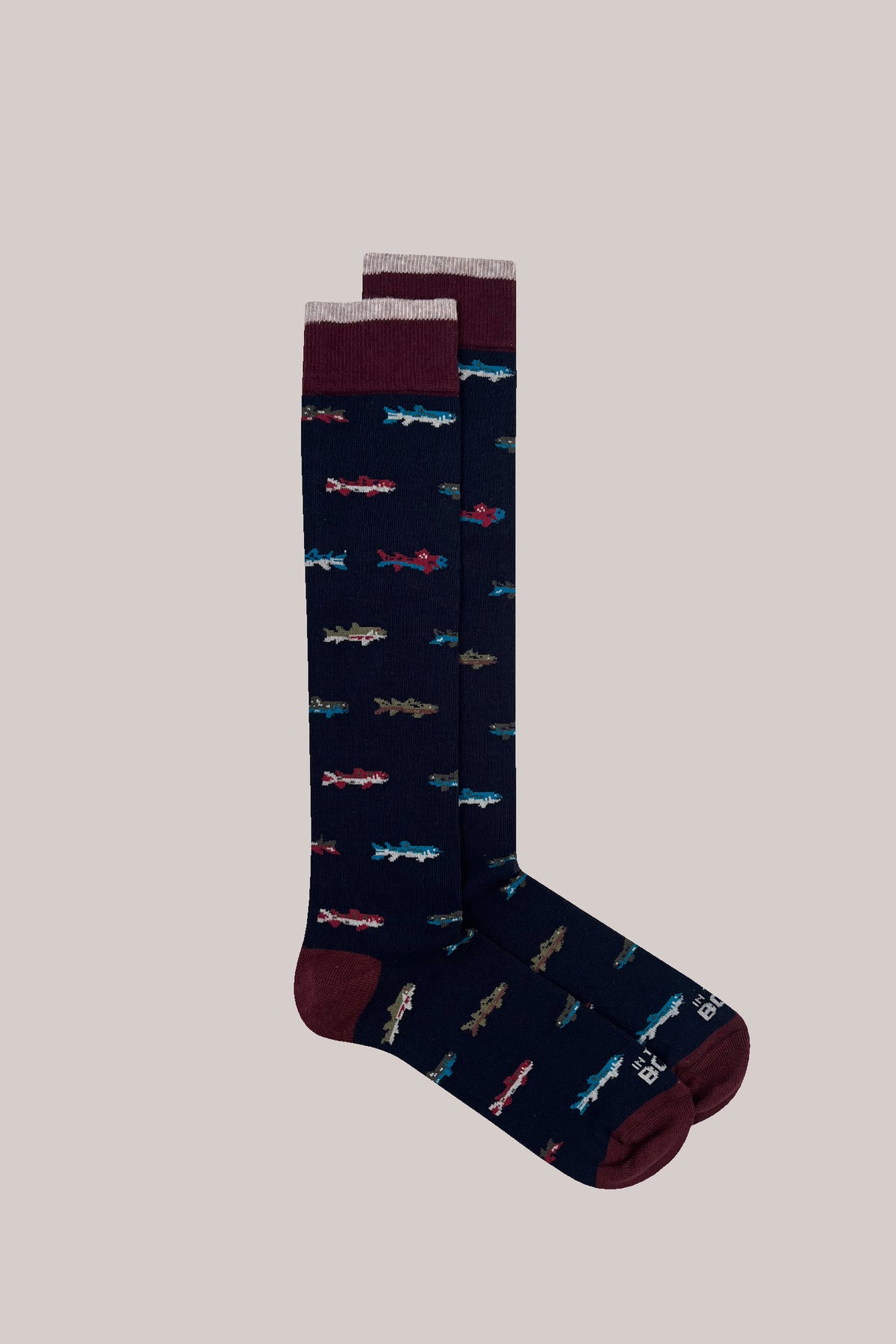Navy socks with an all-over small fish pattern, burgundy heels and toes, and two-tone ribbed cuffs