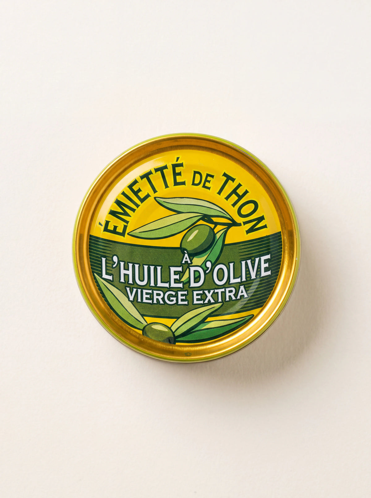 Flaked tuna in olive oil in a round tin with a yellow label reading Émietté de thon à l'huile d'olive vierge extra