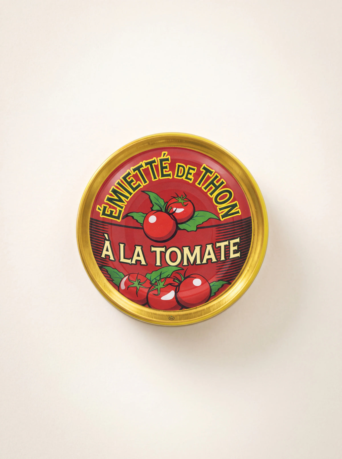 Round tin of flaked tuna with tomato, showing the red and gold lid labelled Émietté de Thon à la Tomate