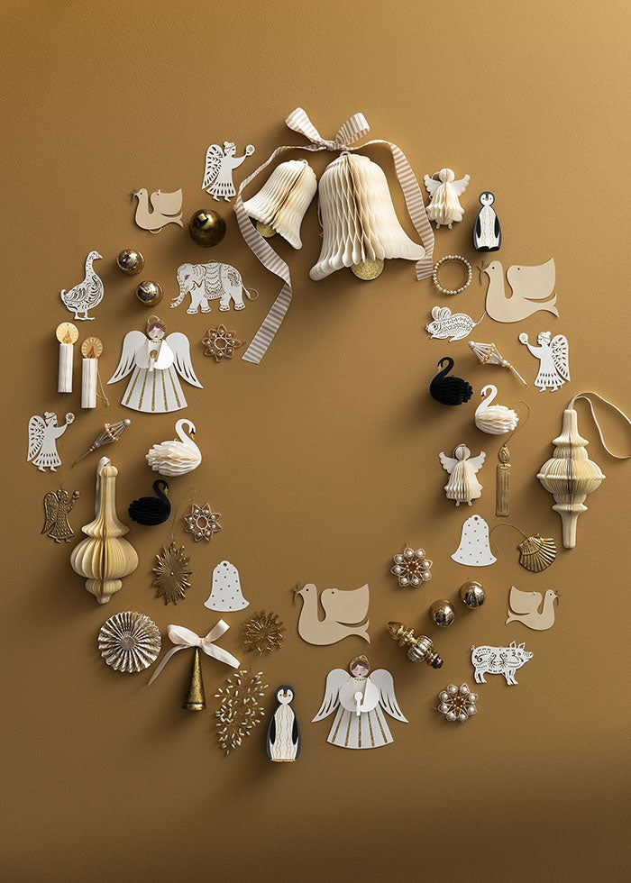 Cream honeycomb ornament arranged in a circular flat lay with assorted festive decorations
