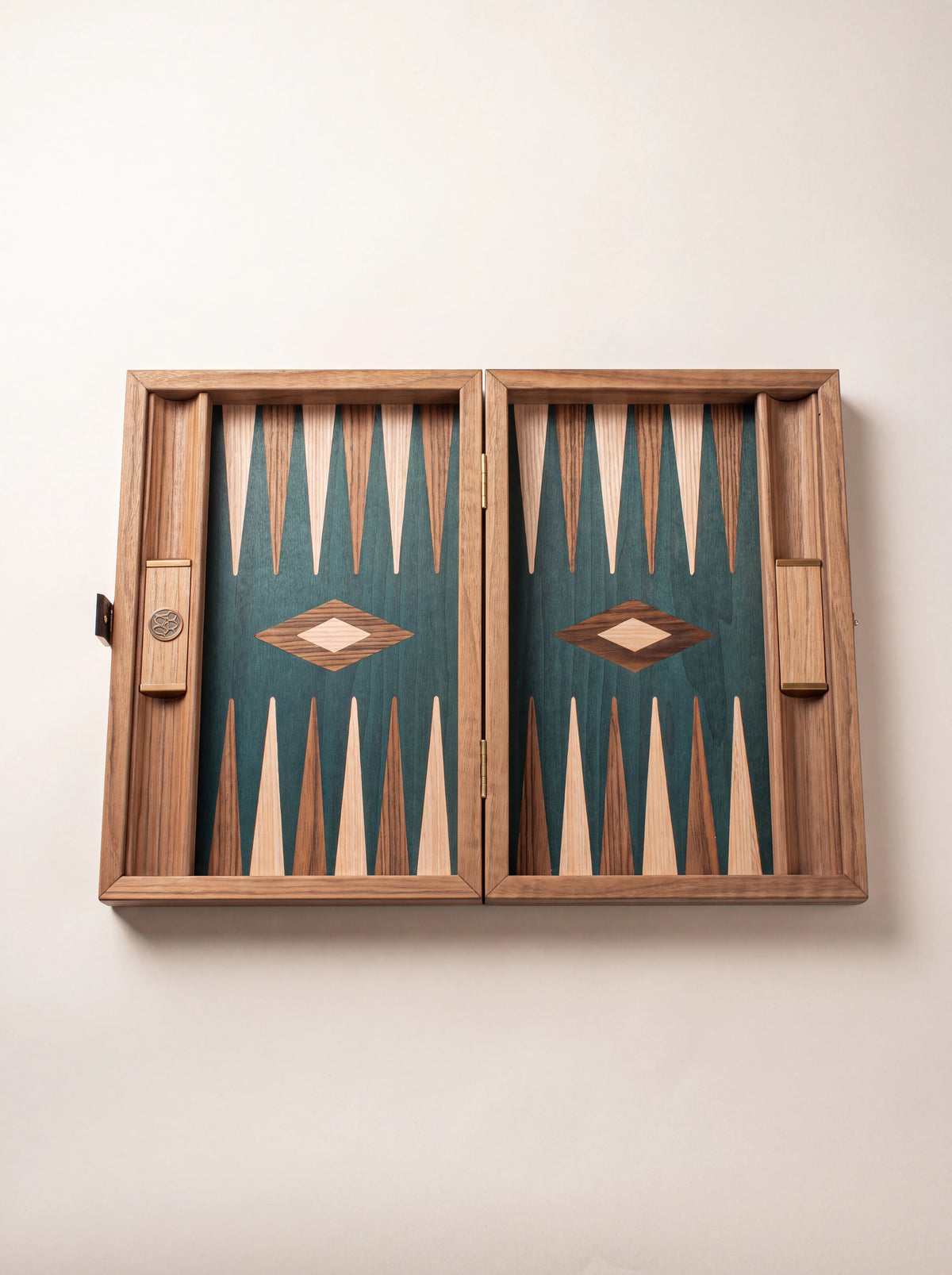 Wooden backgammon board opened without pieces to show the green field, diamond inlays and side racks