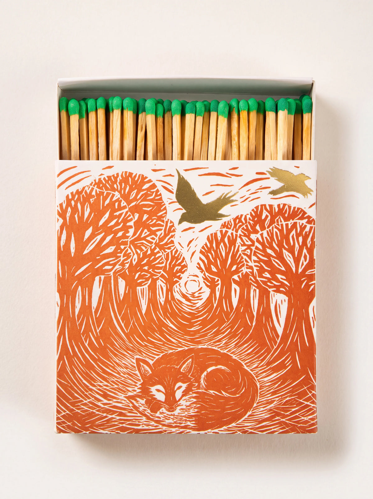 Square matchbox with an orange woodland fox print, open to show green-tipped wooden matches