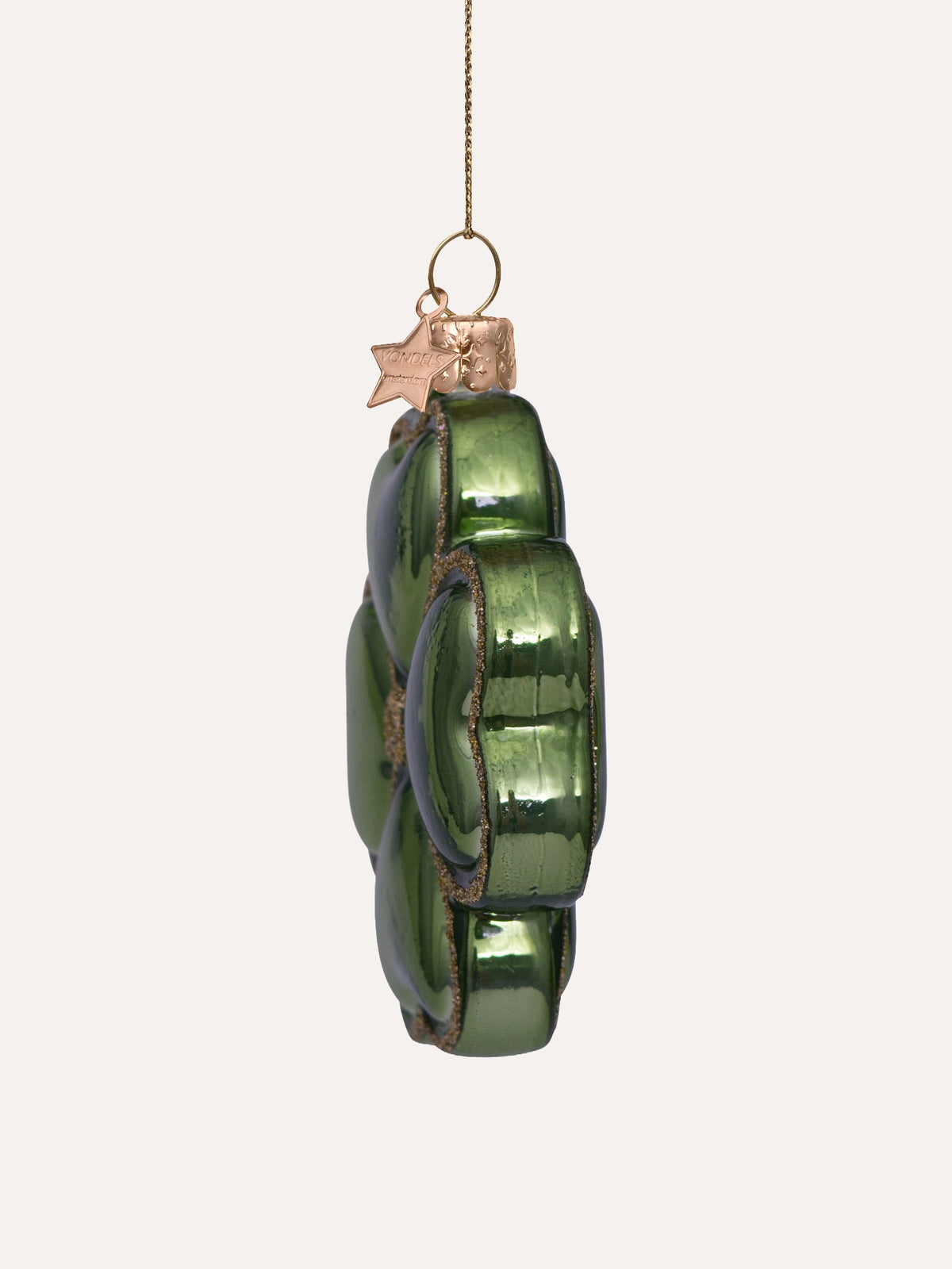 Side view showing the thickness and relief profile of the green glass ornament