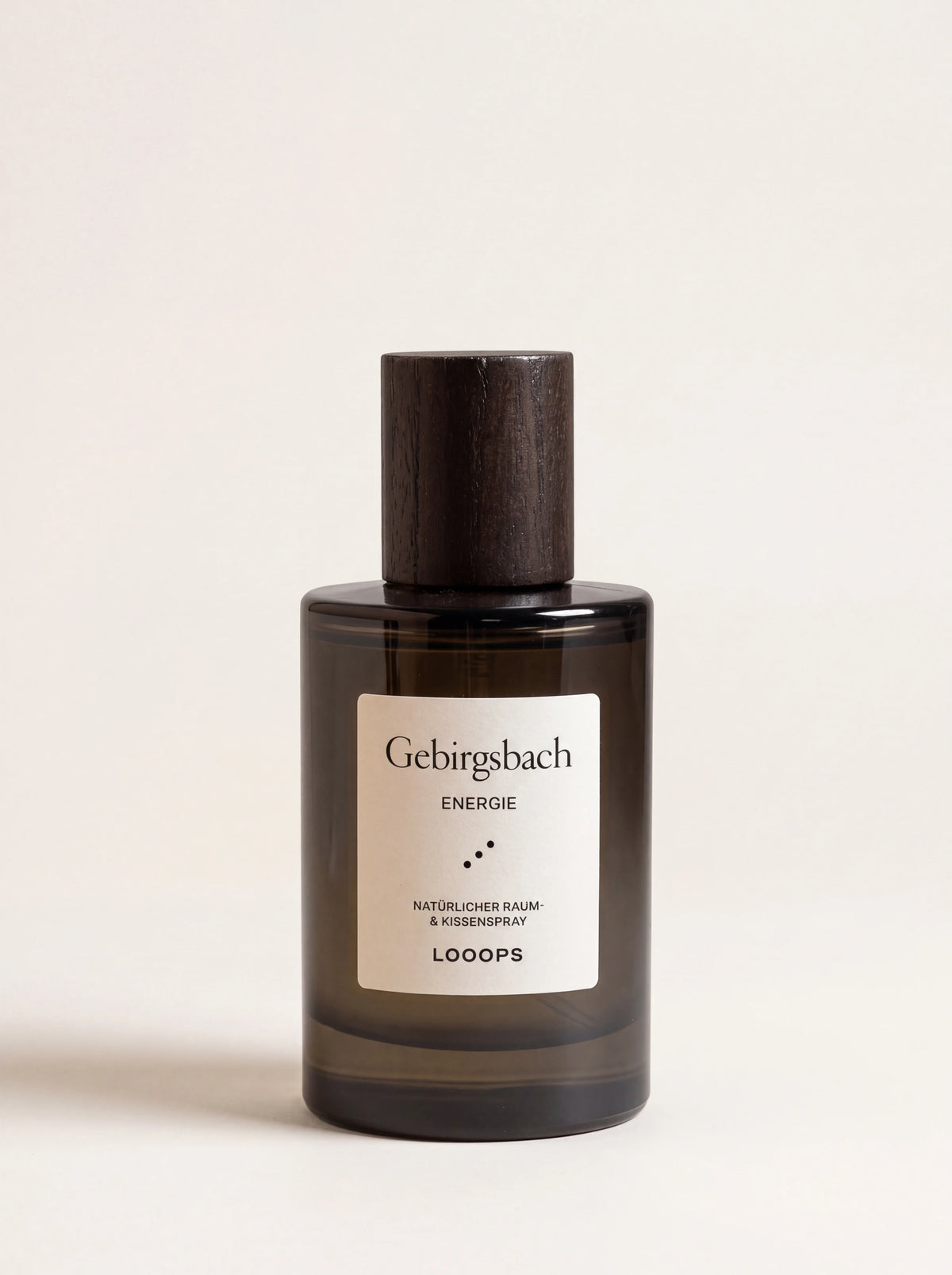 Room spray in a dark glass bottle with a stained ash wood cap and label reading Gebirgsbach Energie