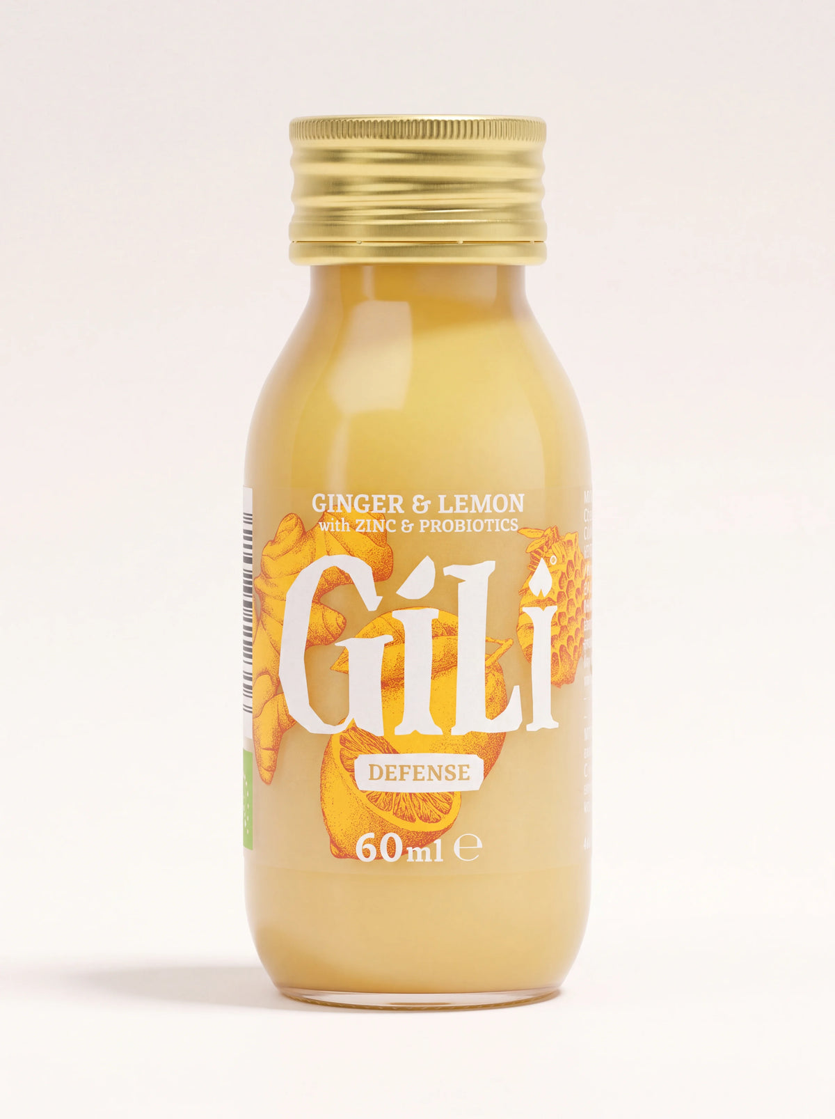 Ginger and lemon elixir shot in a 60 ml glass bottle with a ribbed gold screw cap