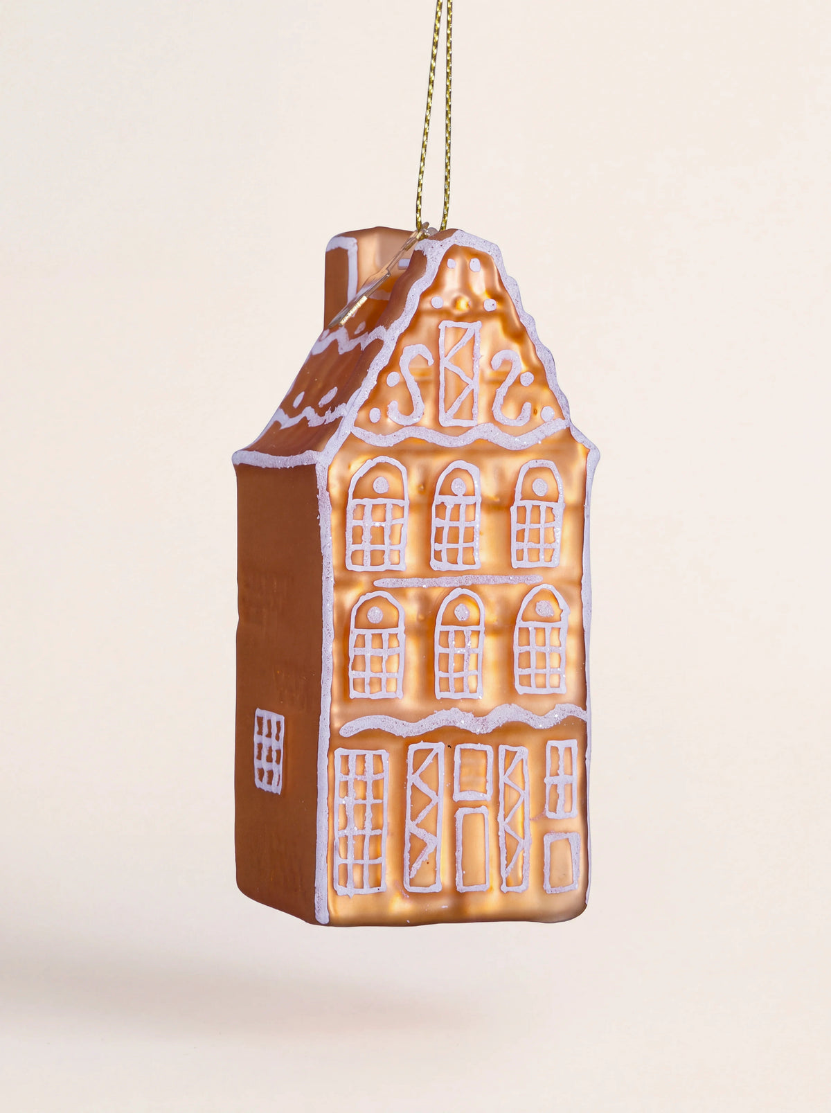 Gingerbread canal house glass Christmas ornament with white painted details and a gold hanging cord