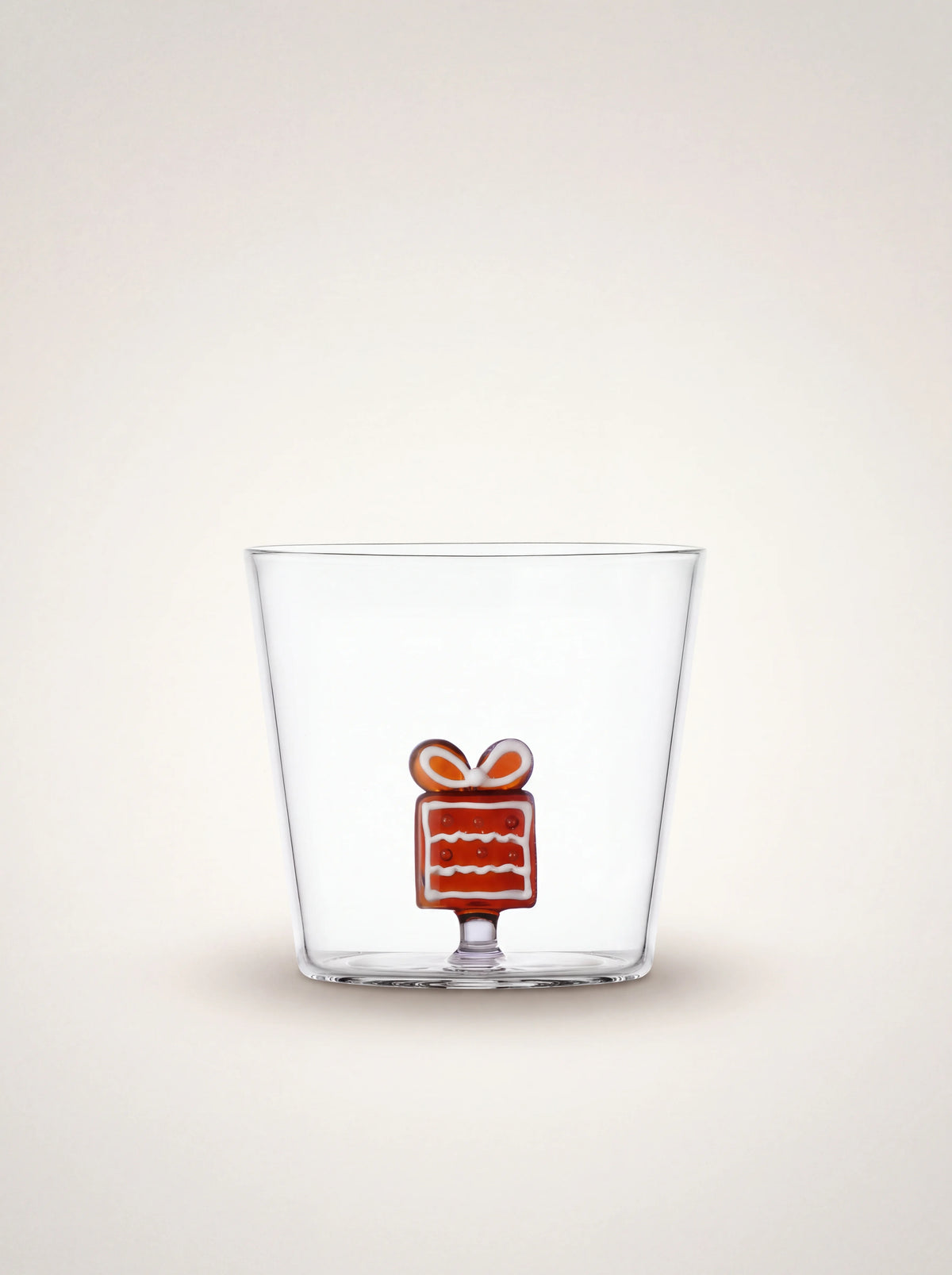 Clear borosilicate glass tumbler with an internal amber glass gingerbread gift figurine at the base