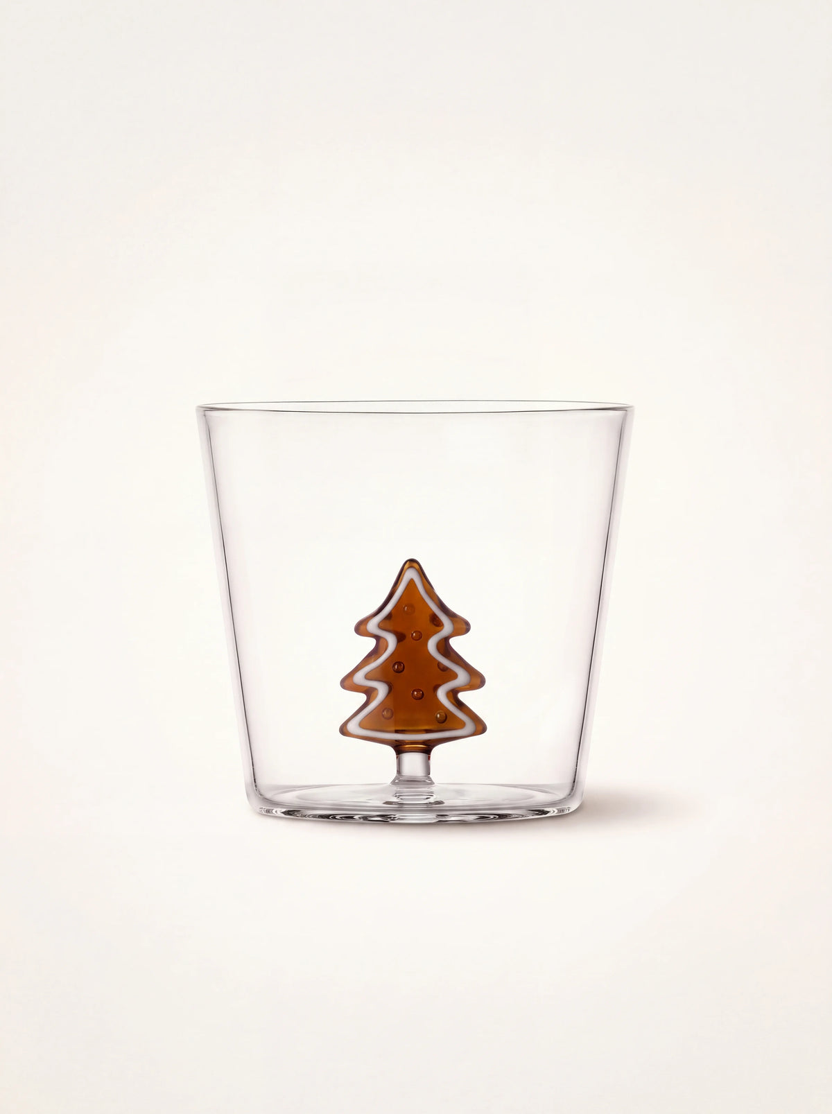 Clear glass tumbler with an internal amber gingerbread tree figurine with white accents