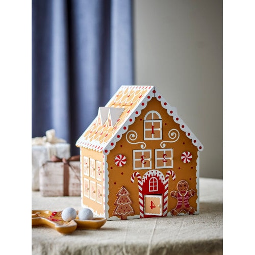 Gingerbread house Advent calendar set on a tabletop alongside wrapped gift boxes