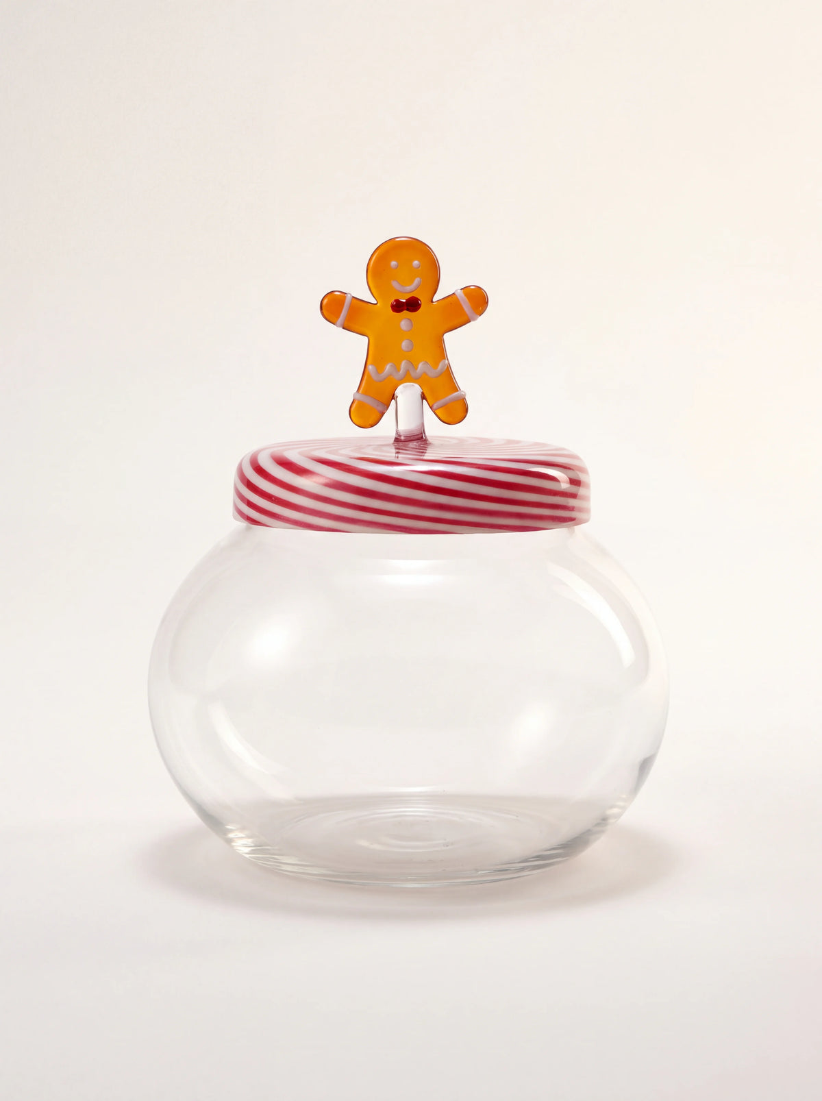 Clear glass cookie box with a red-and-white striped lid topped by a gingerbread man figurine handle