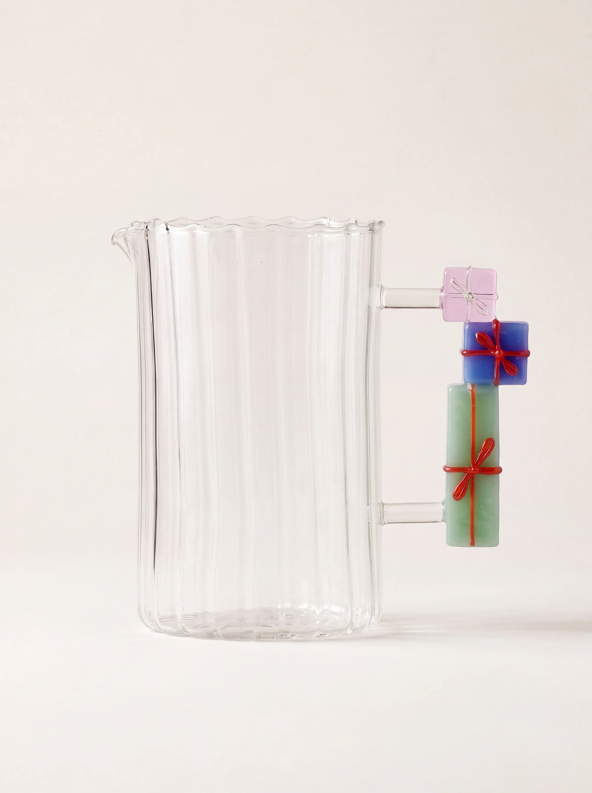 Fluted clear glass jug with scalloped rim and a handle formed of stacked coloured glass gift boxes