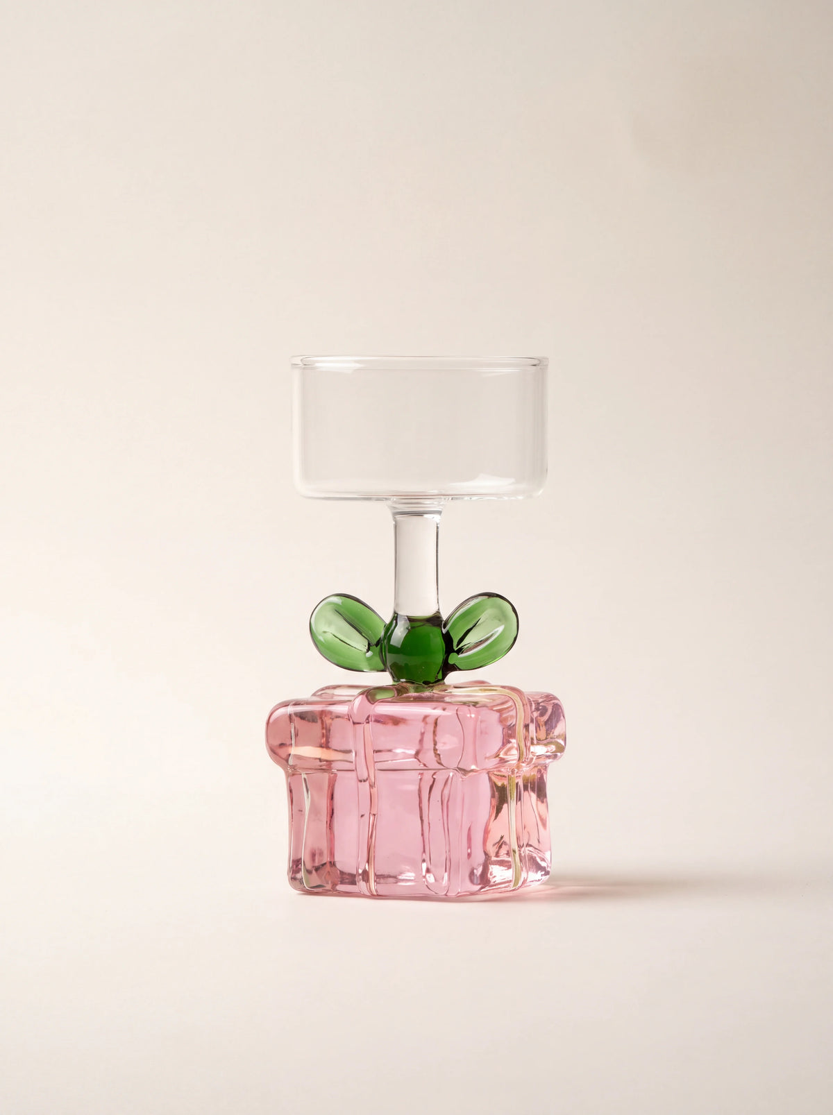 Pink borosilicate glass tealight holder with a gift parcel base, green bow and clear cylindrical cup