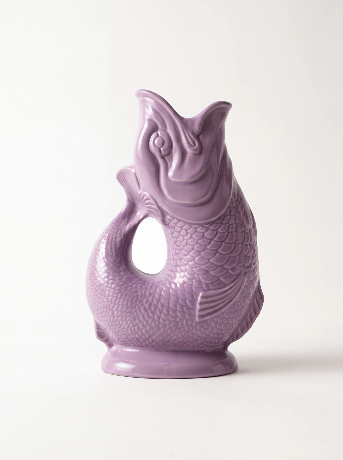 Lilac glazed porcelain fish jug with embossed scales, an open mouth spout and curved tail handle
