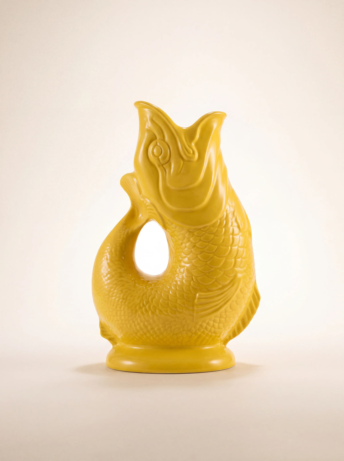Yellow glazed porcelain fish-shaped jug with an open mouth spout and curved tail handle