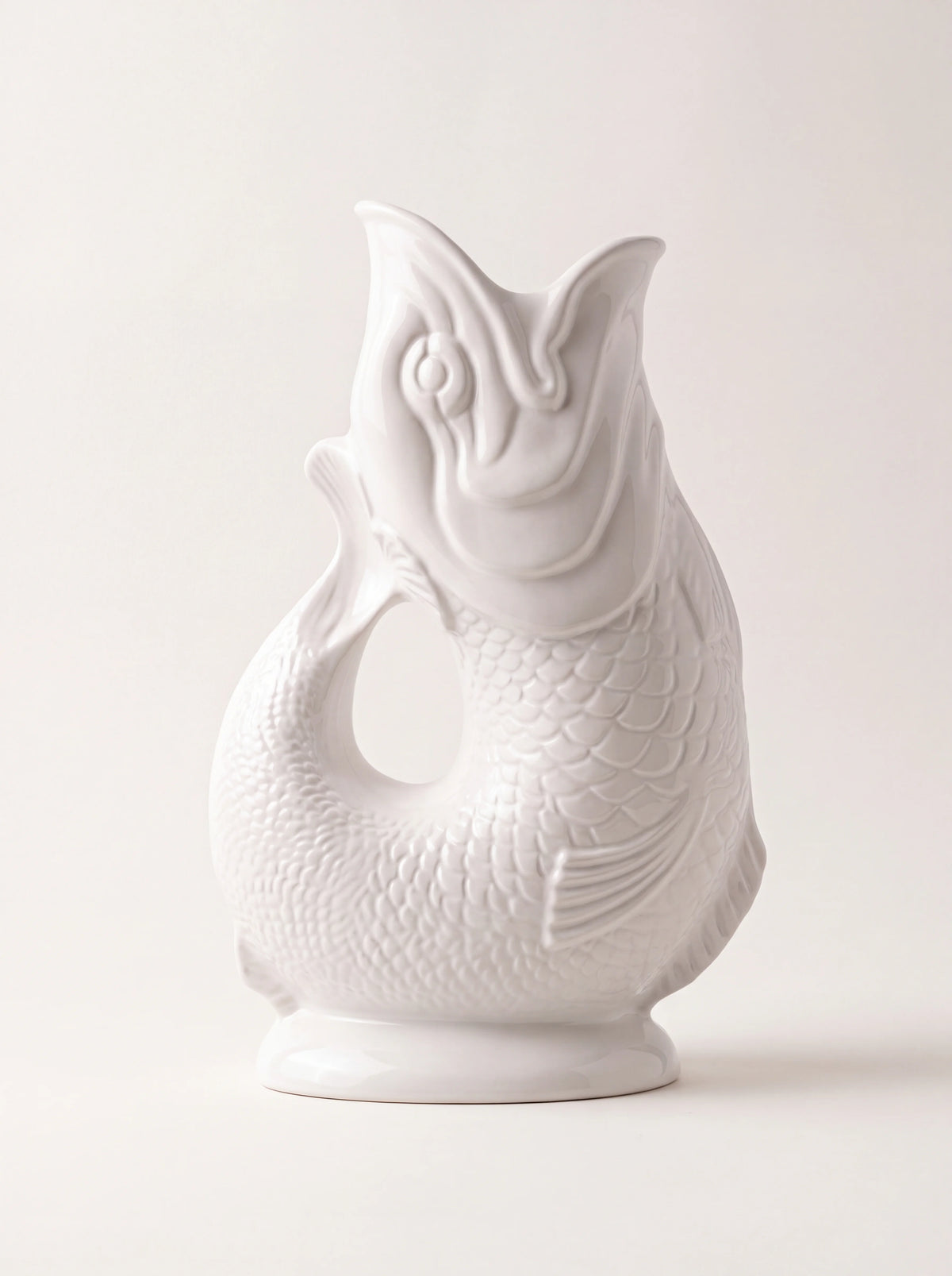 White glazed porcelain gluggle jug shaped as a fish with an open-mouth spout and embossed scales
