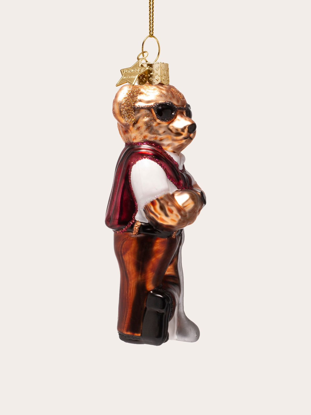Side profile of the glass bear ornament showing the crossed arms and posture