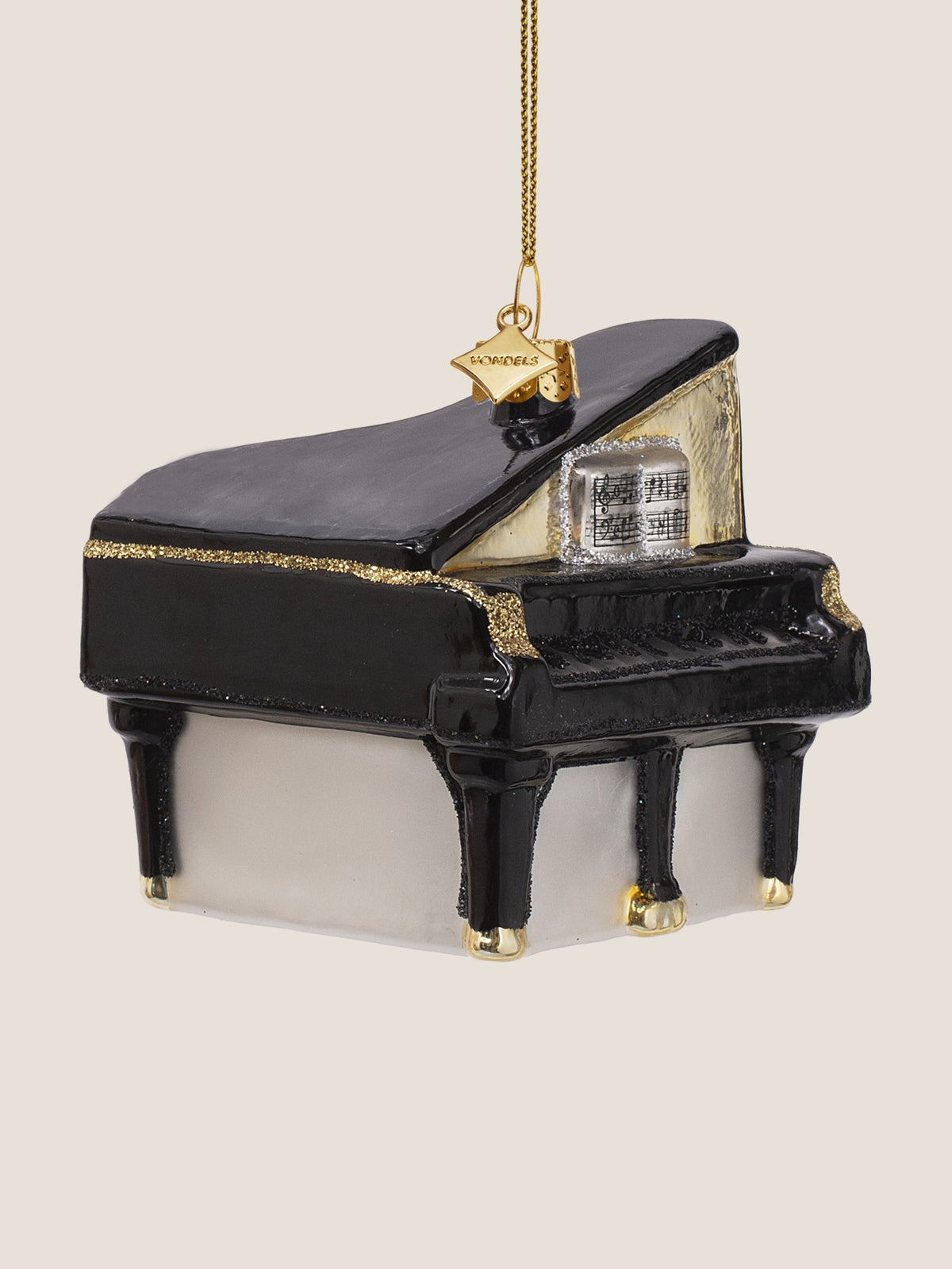 Three-quarter view of the grand piano ornament showing the curved black lid with gold glitter trim