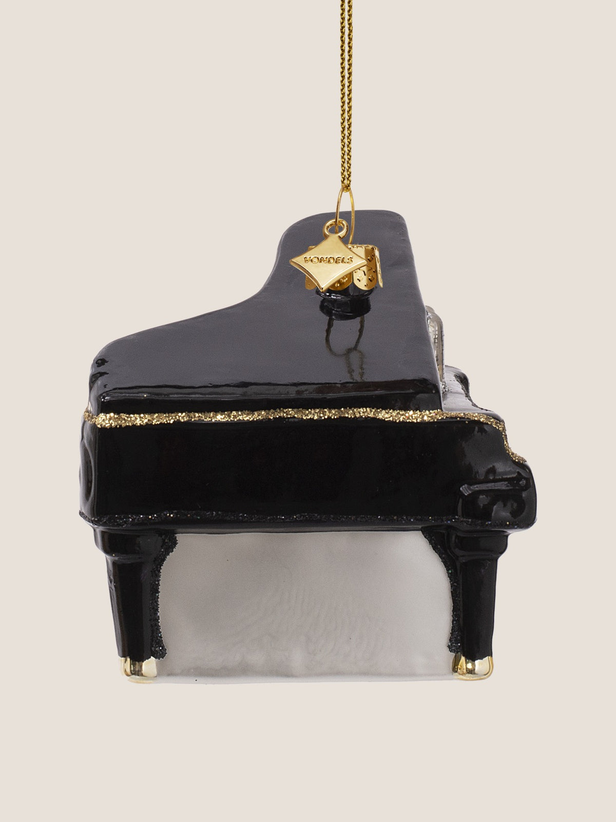 Side profile of the grand piano ornament highlighting the curved black body and glitter rim