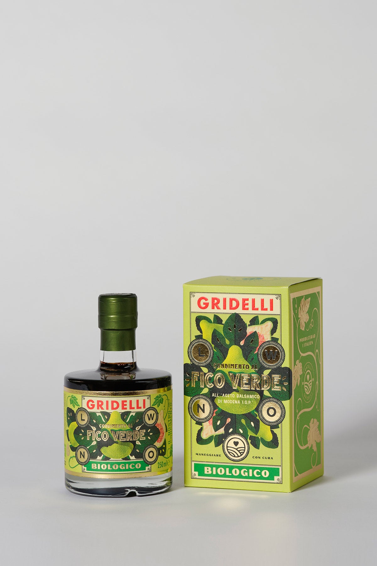 Green fig balsamic vinegar bottle standing beside its matching illustrated green presentation box