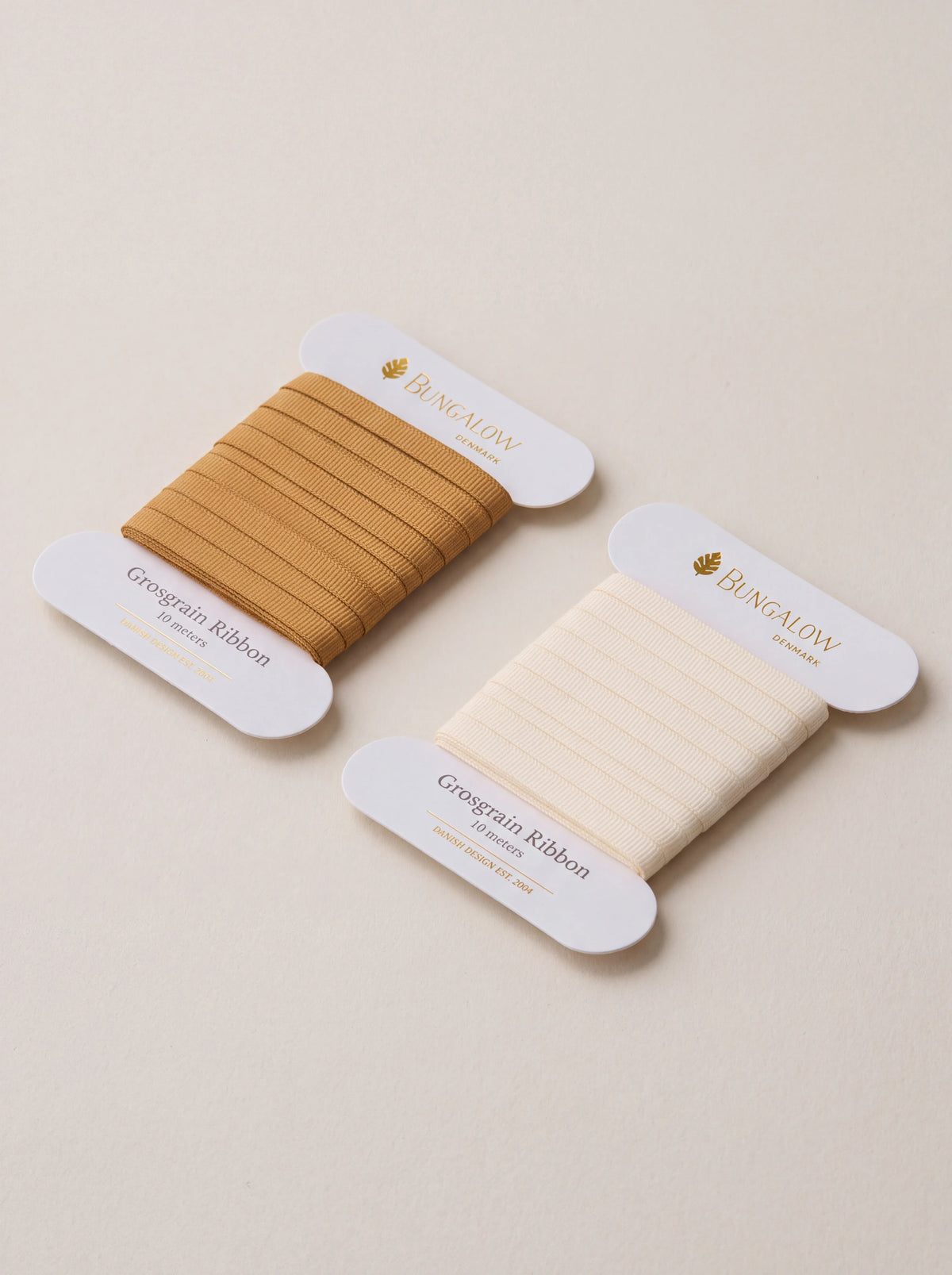 Grosgrain ribbon set in cream and warm tan, wound on flat white cardboard cards