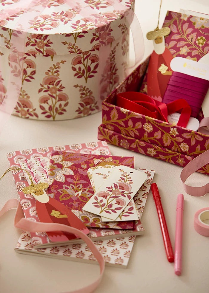 Grosgrain ribbon spools displayed in a floral gift box with gift tags and stationery