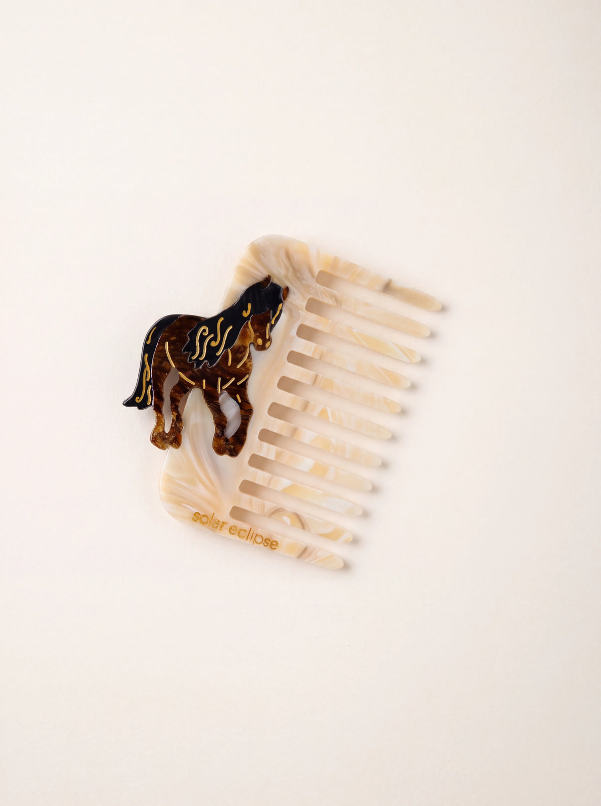Marbled cream acetate pocket comb with wide teeth and a hand-painted horse motif, stamped solar eclipse