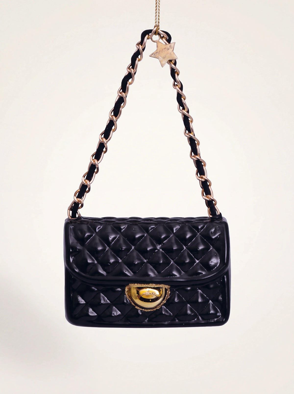 Black quilted glass handbag ornament with a gold-tone clasp and interwoven chain strap