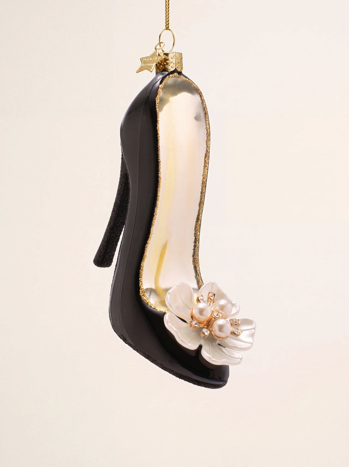 Black glass high-heel ornament with gold glitter rim and a white flower embellishment at the toe